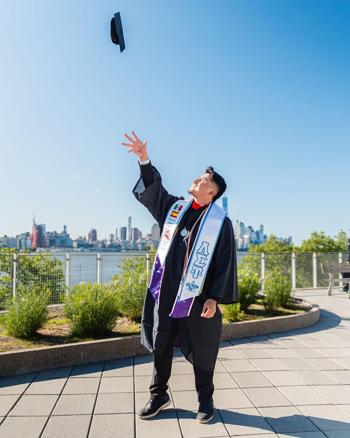 Humberto Flores ’25 tosses his graduation cap at the Babbio patio 