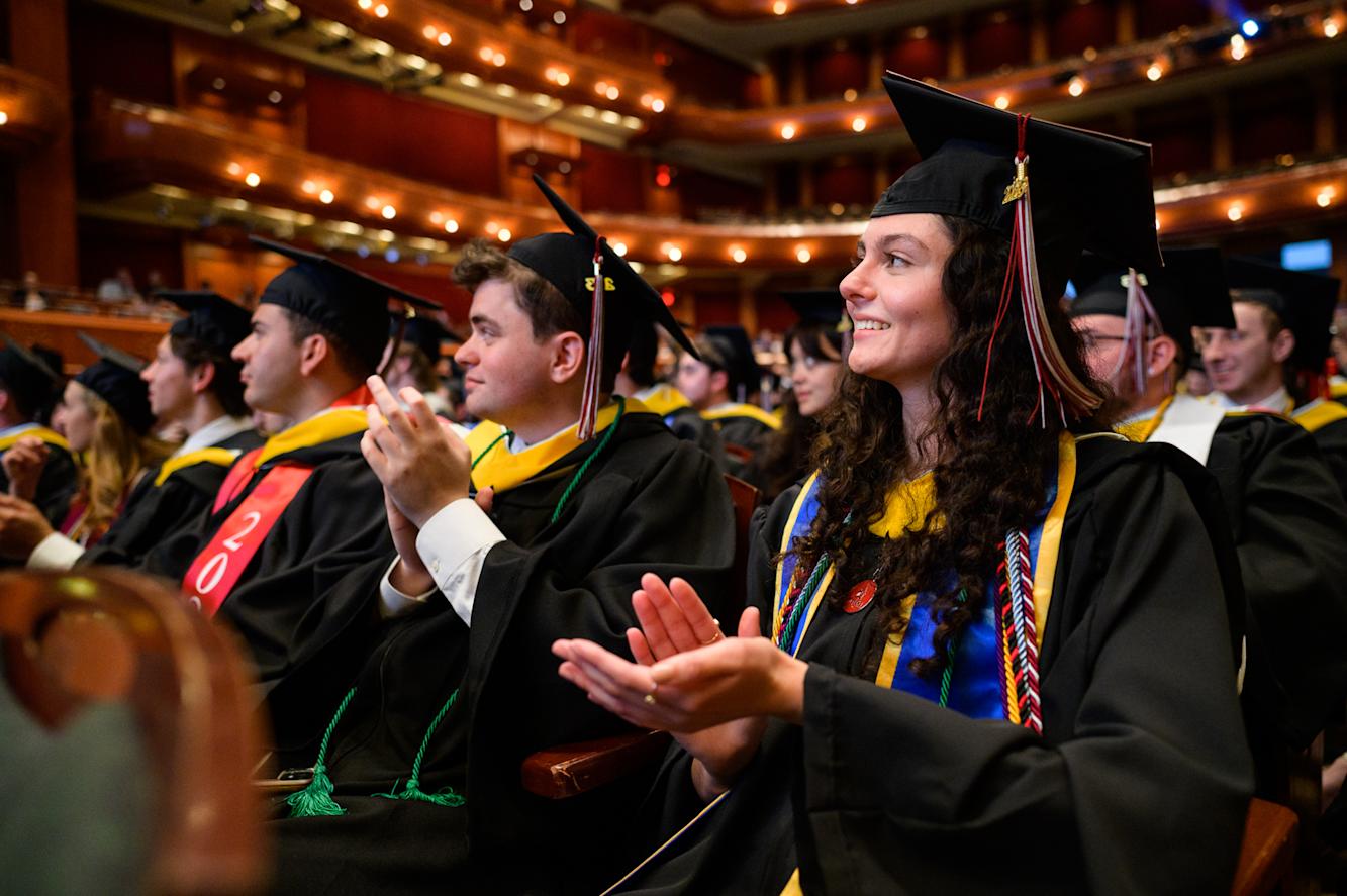 Students applaud classmates receiving their diplomas 