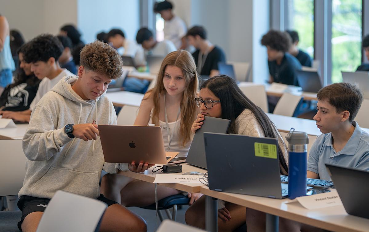 A group of School of Business pre-college students work together on building an AI app. 