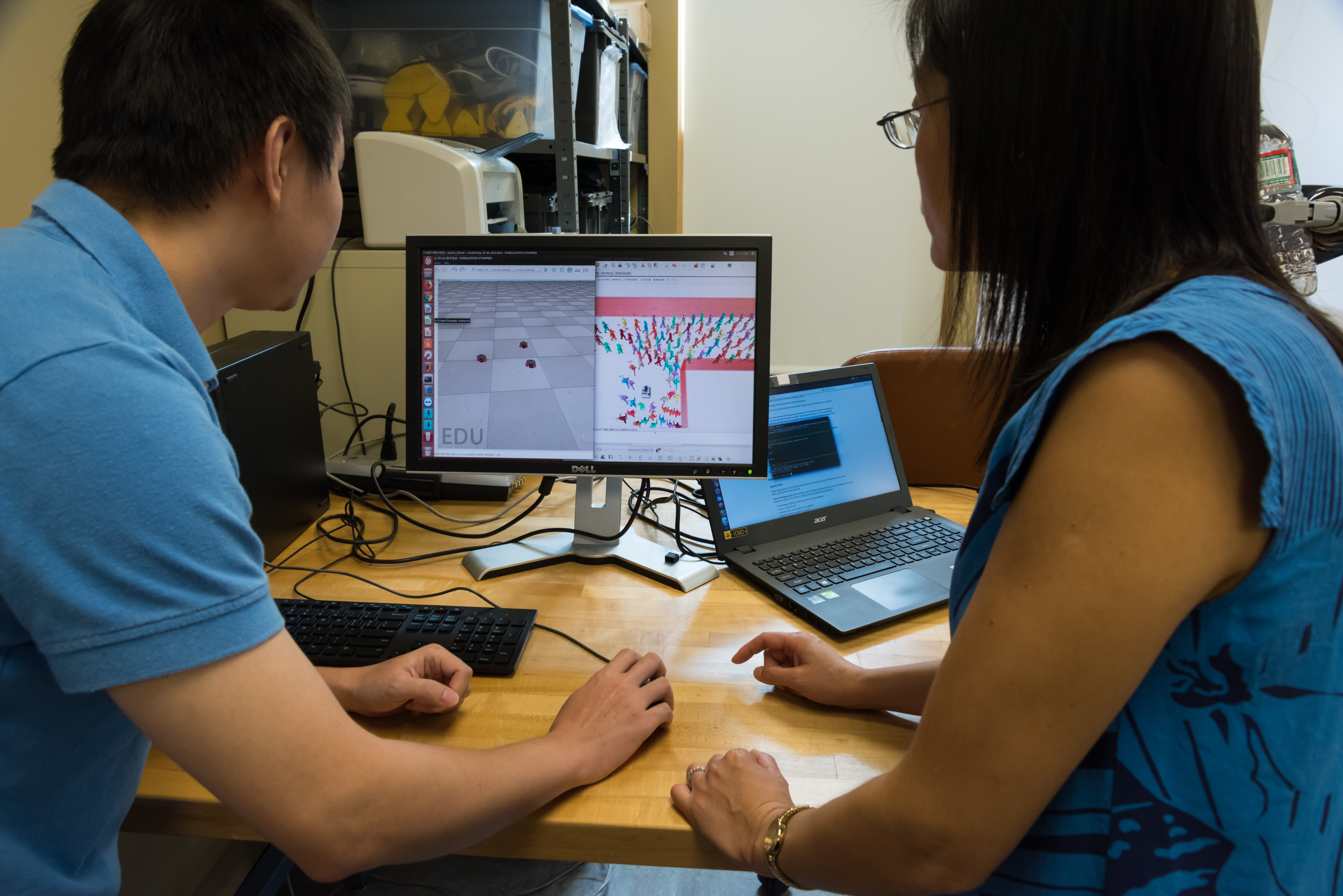 Yi Guo and student looking at a computer