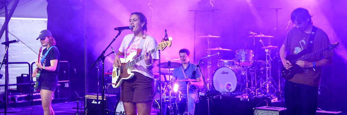 Student band on stage playing music with dramatic lighting.