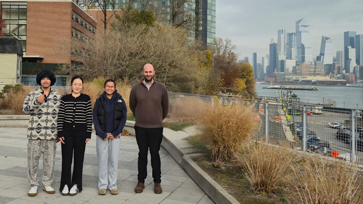 Simon Mahler posing with his lab group on Stevens campus in front of the New York City skyline.