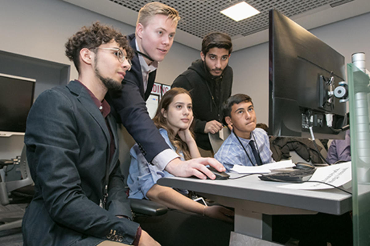 Austin McDonnell helps a team of high school students in the lab.