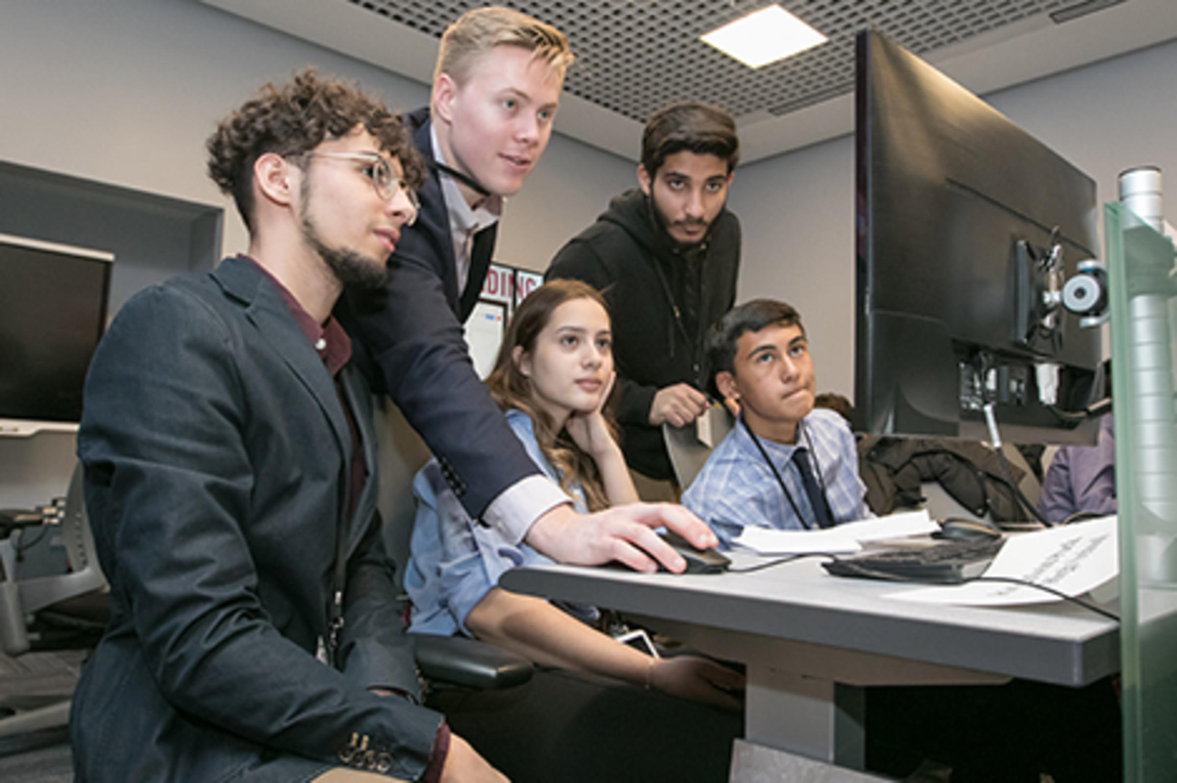 Austin McDonnell helps a team of high school students in the lab.
