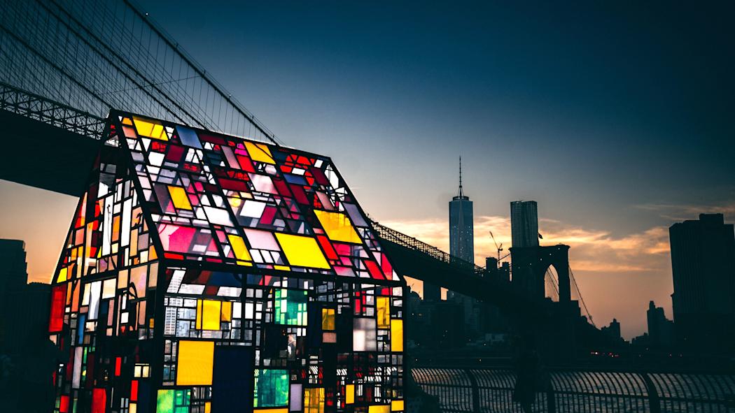 Mosaic-colored glass house by a New York City river