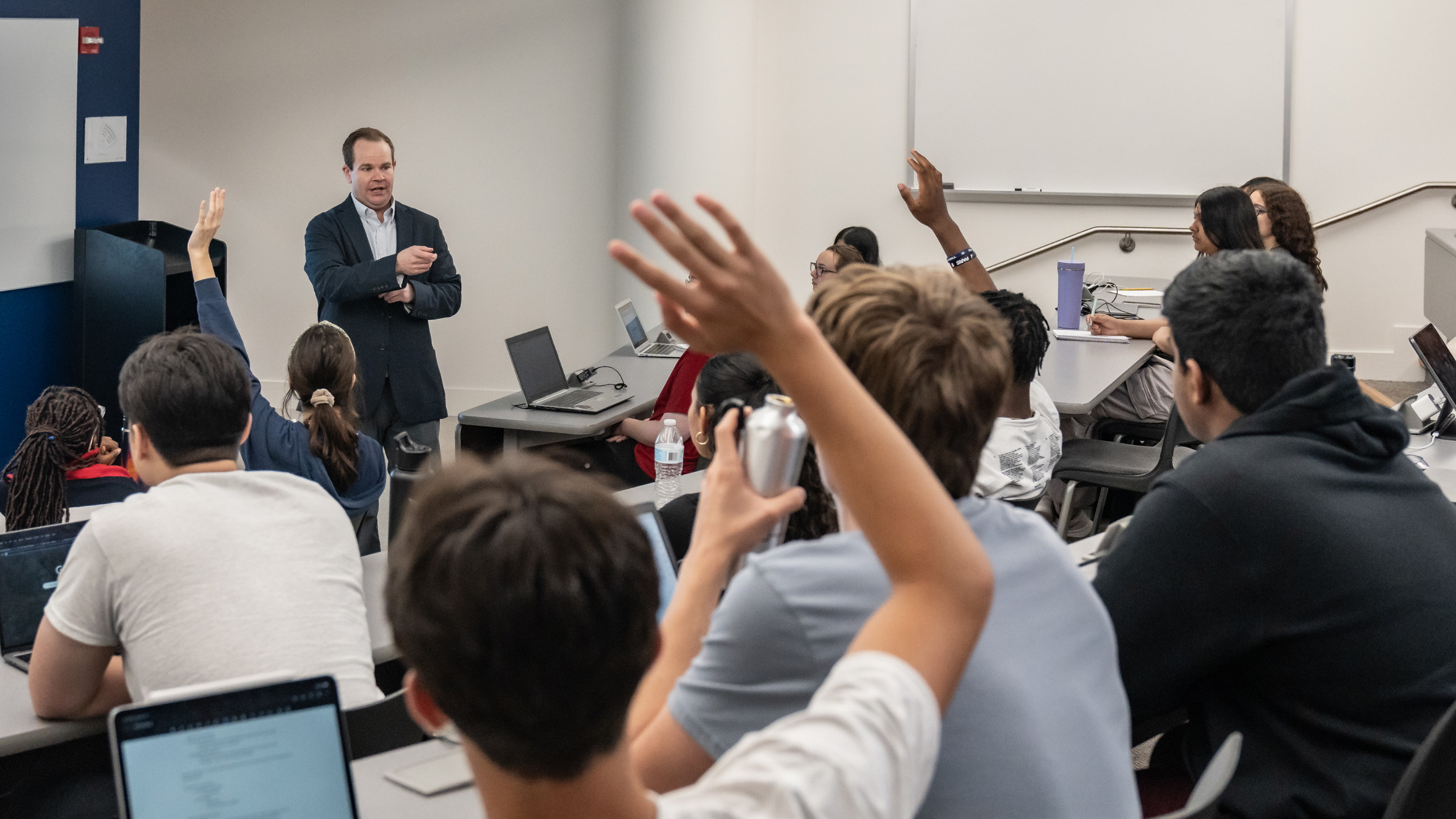 Studnent in a lecture raising their hands