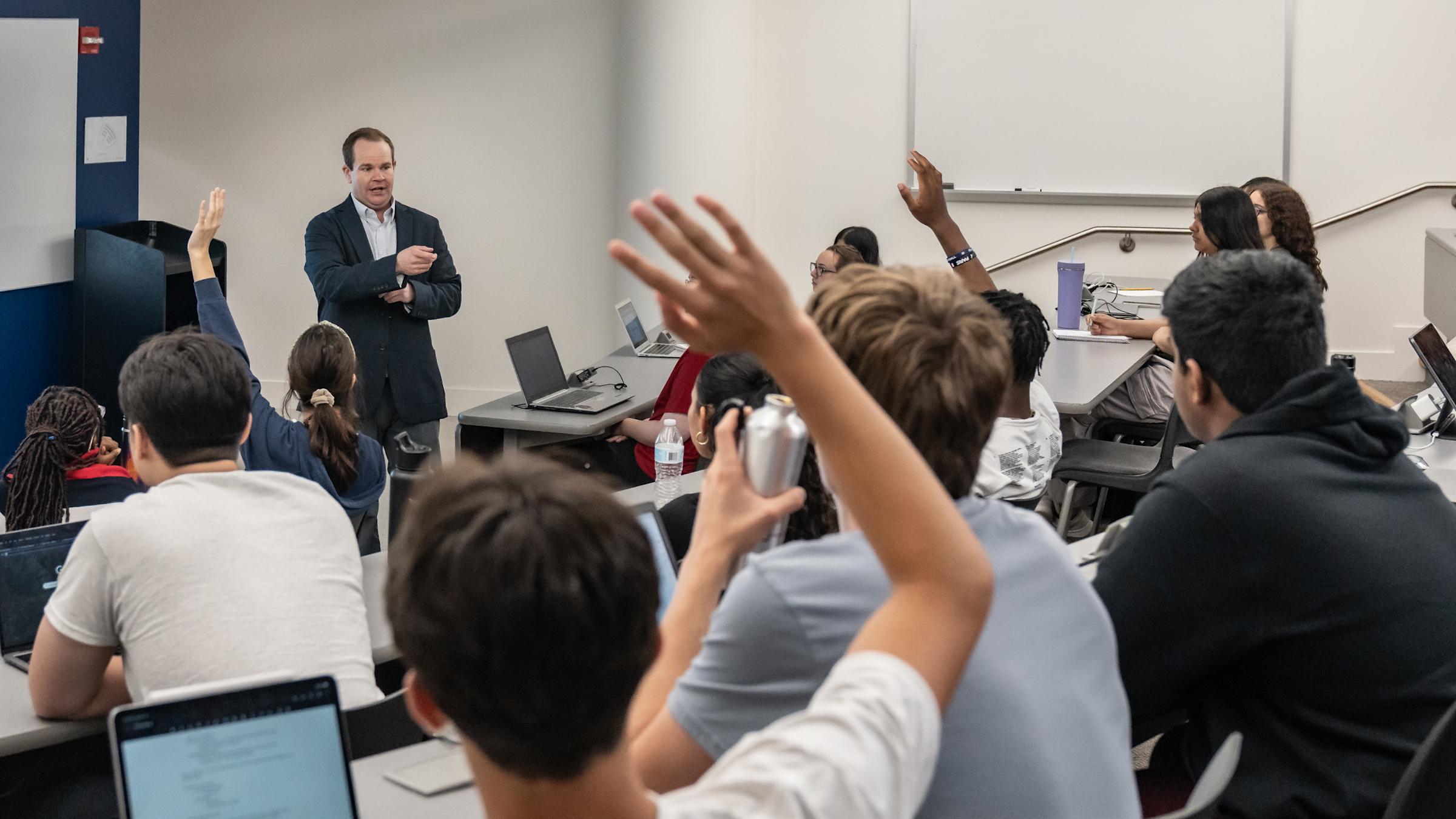 Studnent in a lecture raising their hands
