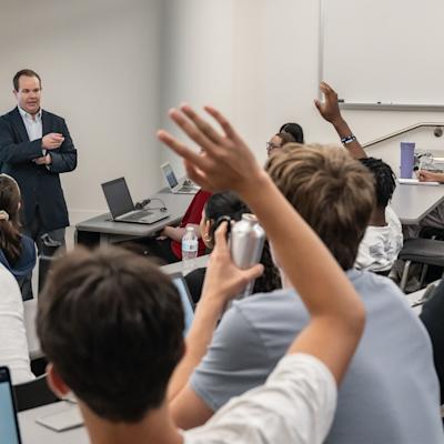Studnent in a lecture raising their hands