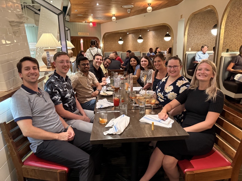 Young alumni gather at a meal together for a Dine with Ducks event