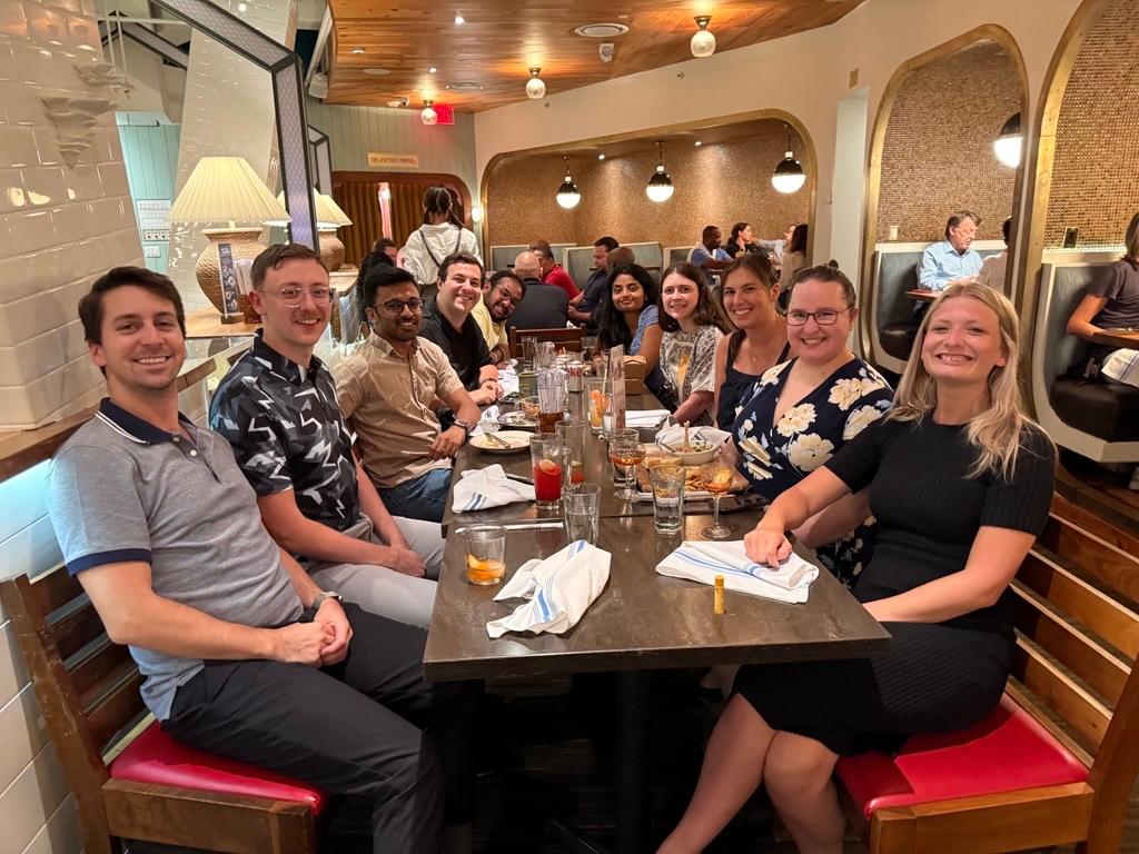 Young alumni gather at a meal together for a Dine with Ducks event