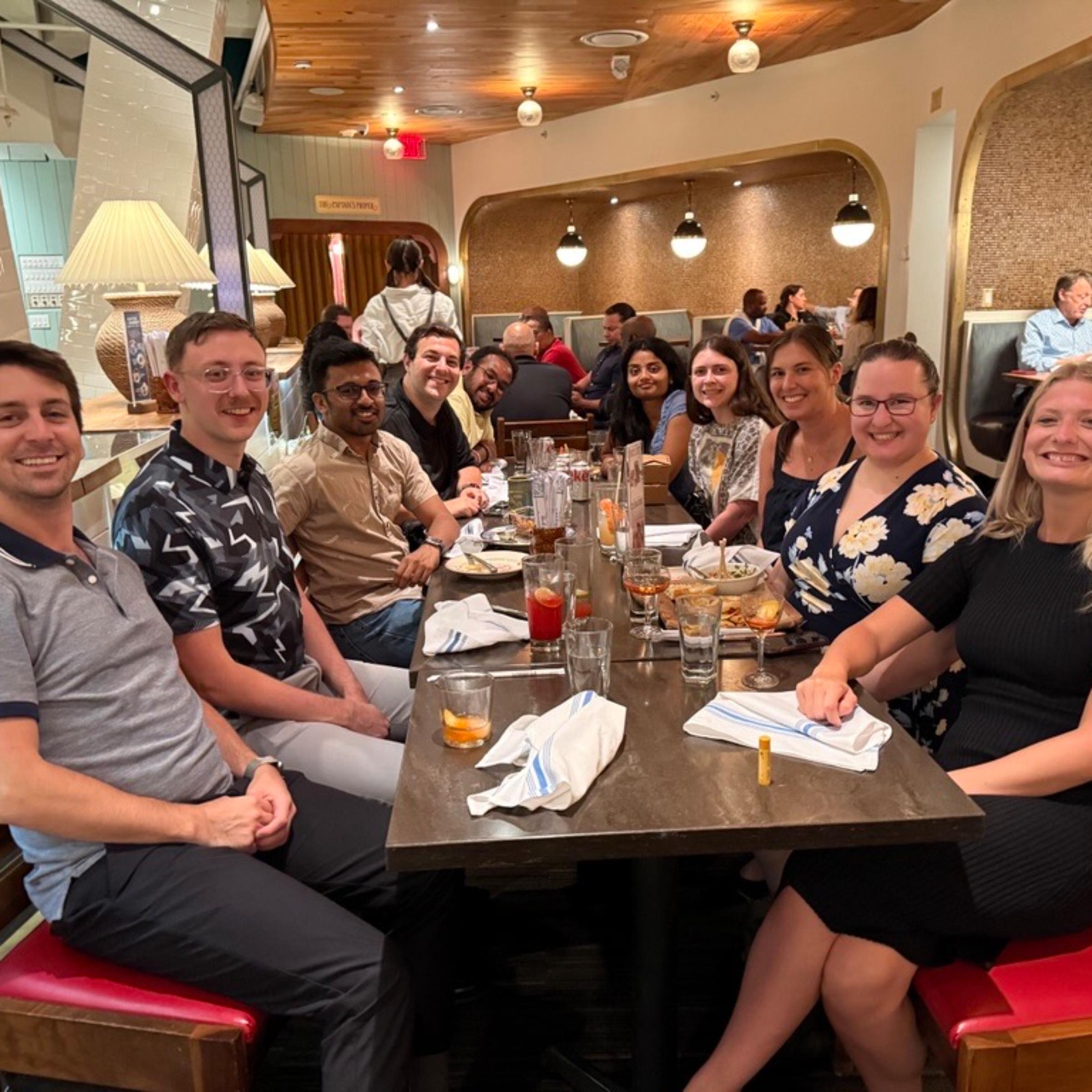 Young alumni gather at a meal together for a Dine with Ducks event