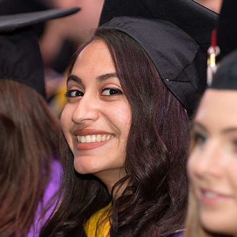 Sheila smiling in a graduation cap