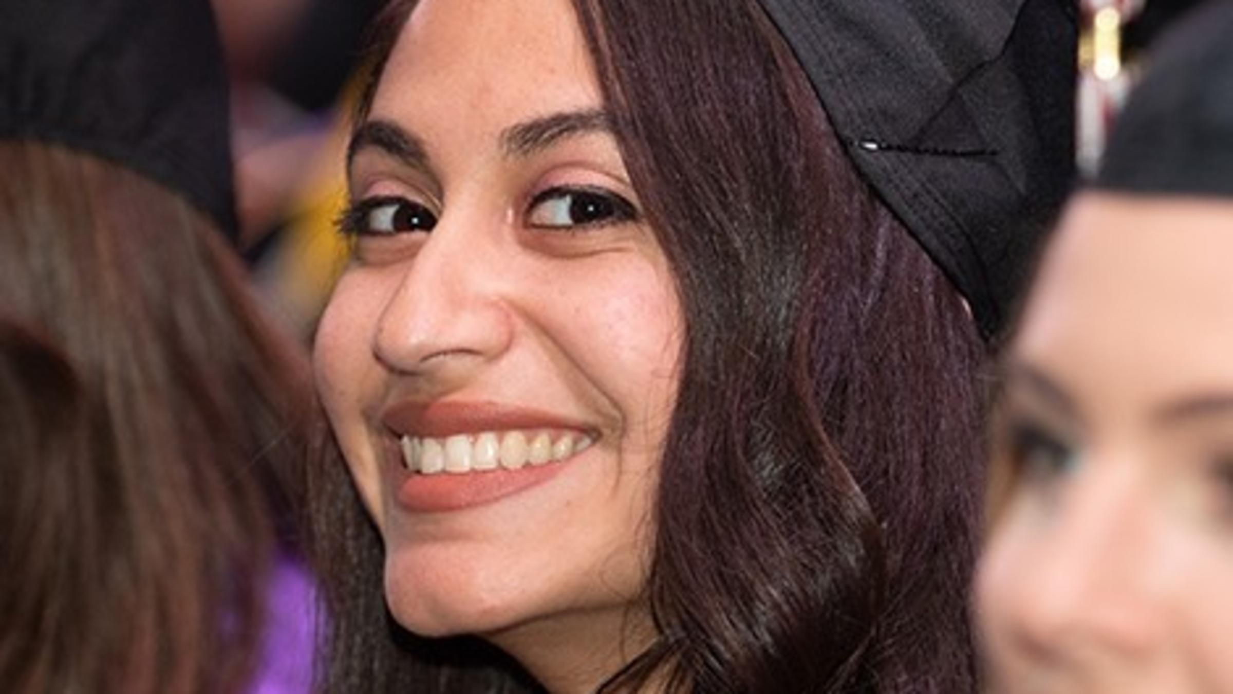 Sheila smiling in a graduation cap