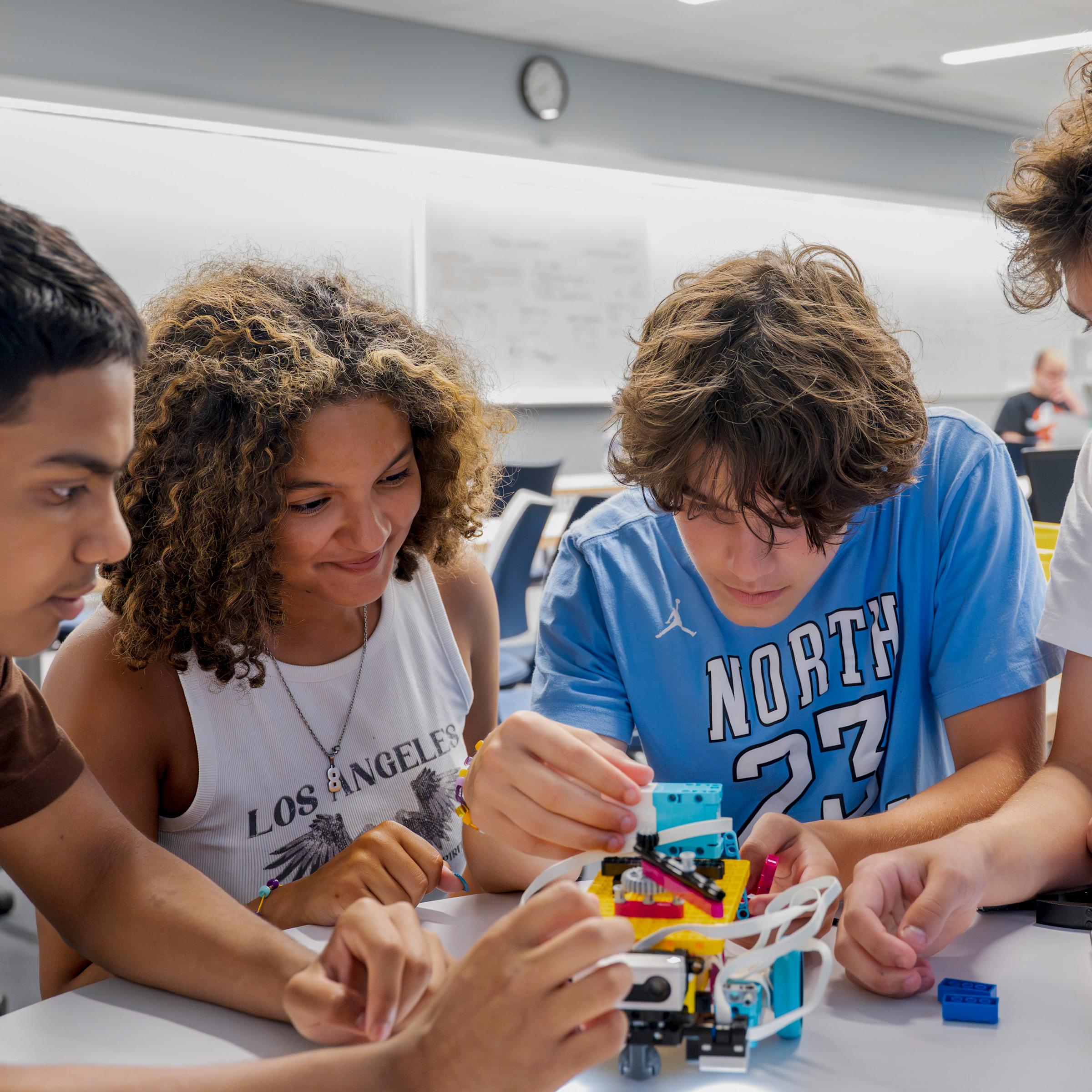 Students working together in lab on small robot
