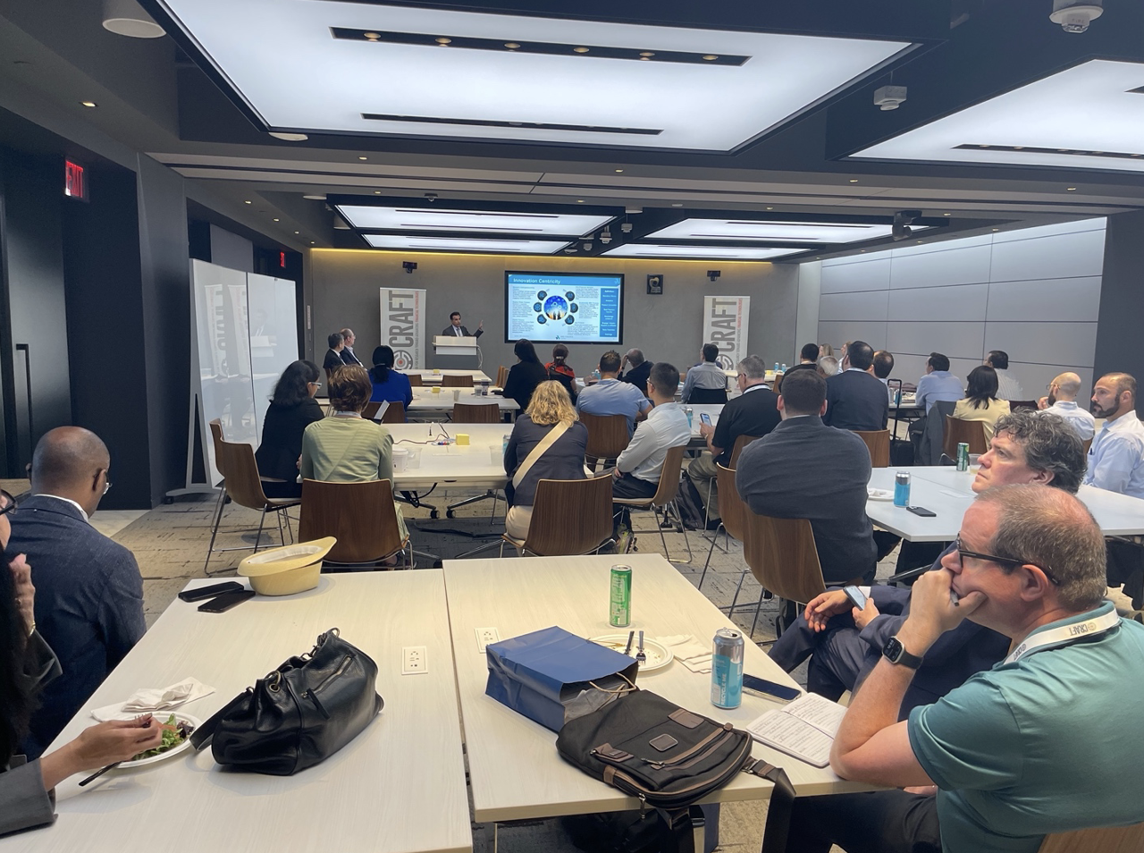 Participants sit in conference room listening to a presentation