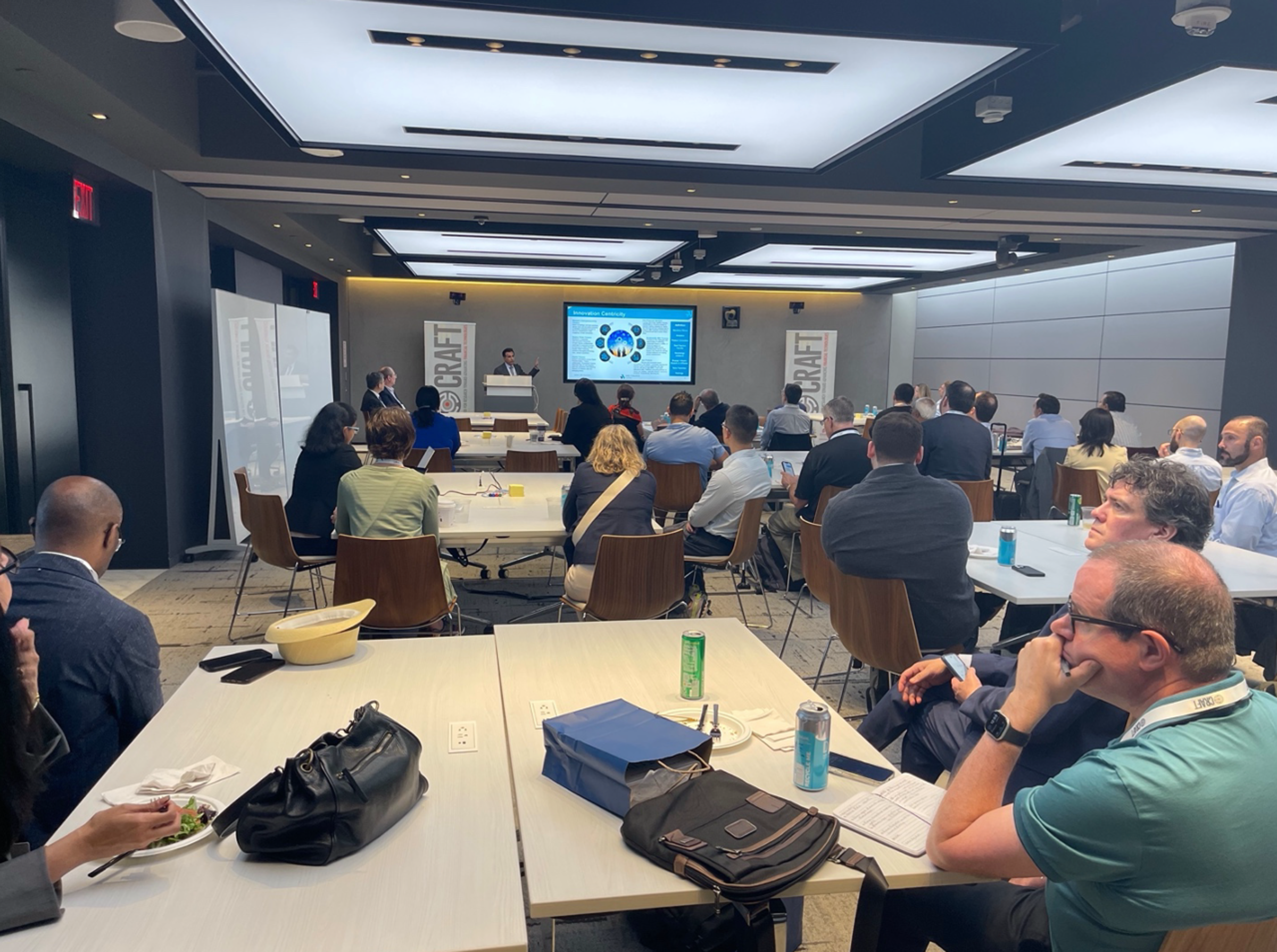 Participants sit in conference room listening to a presentation
