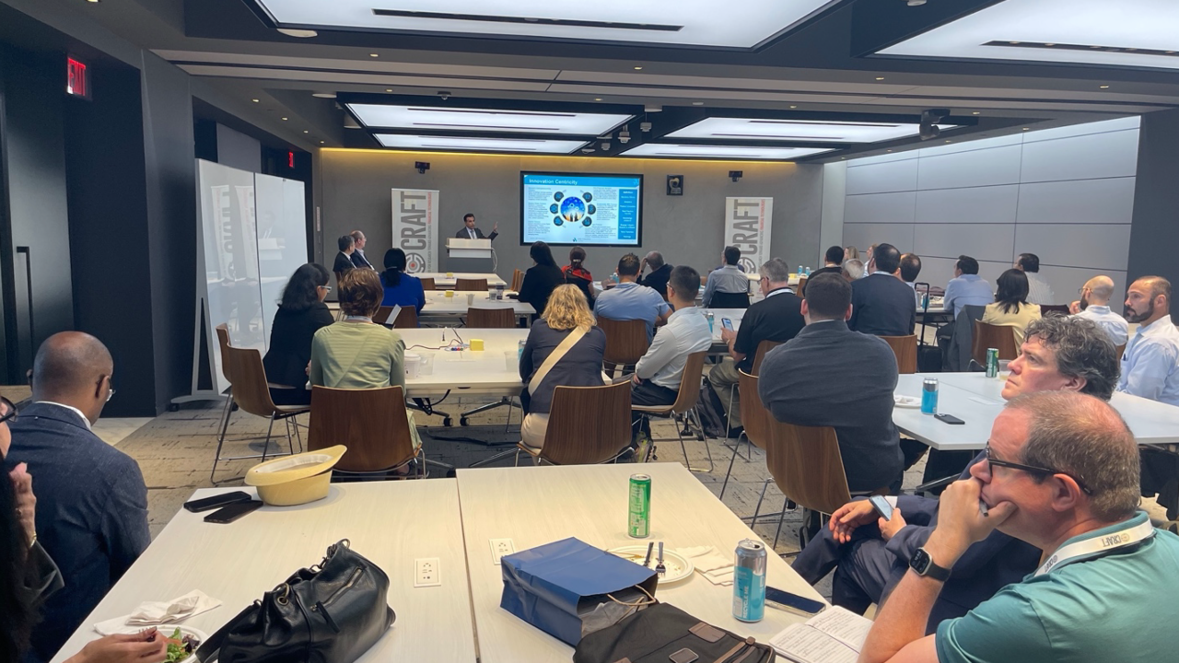 Participants sit in conference room listening to a presentation