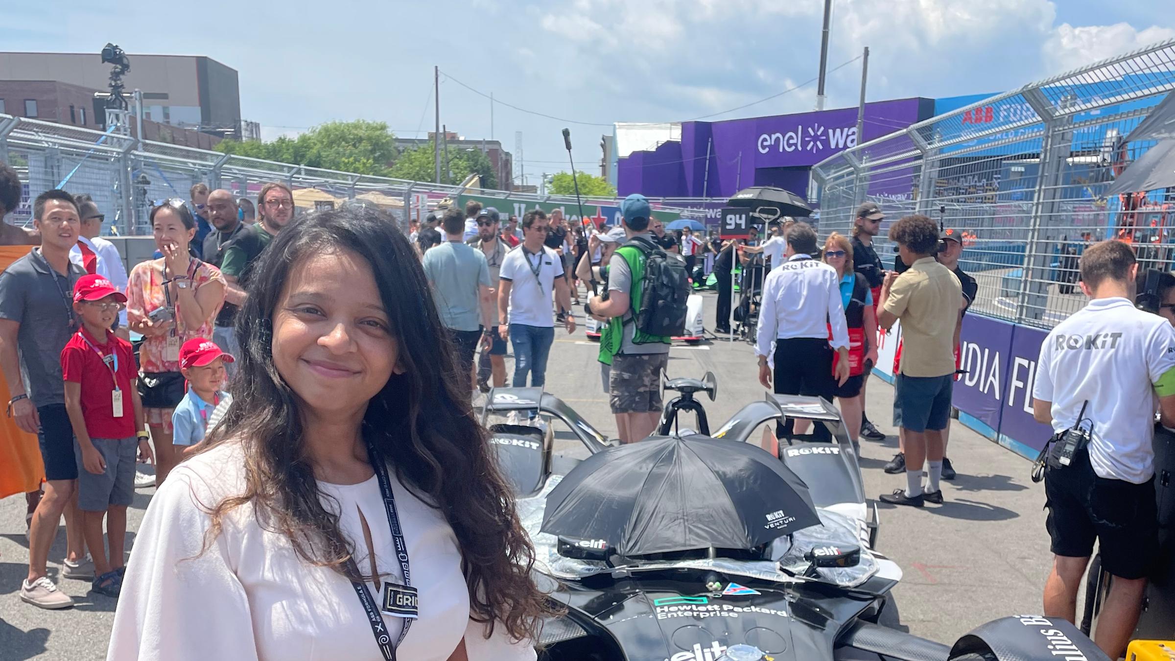 Kinjal Shukla stands next to a blue Formula E race car.
