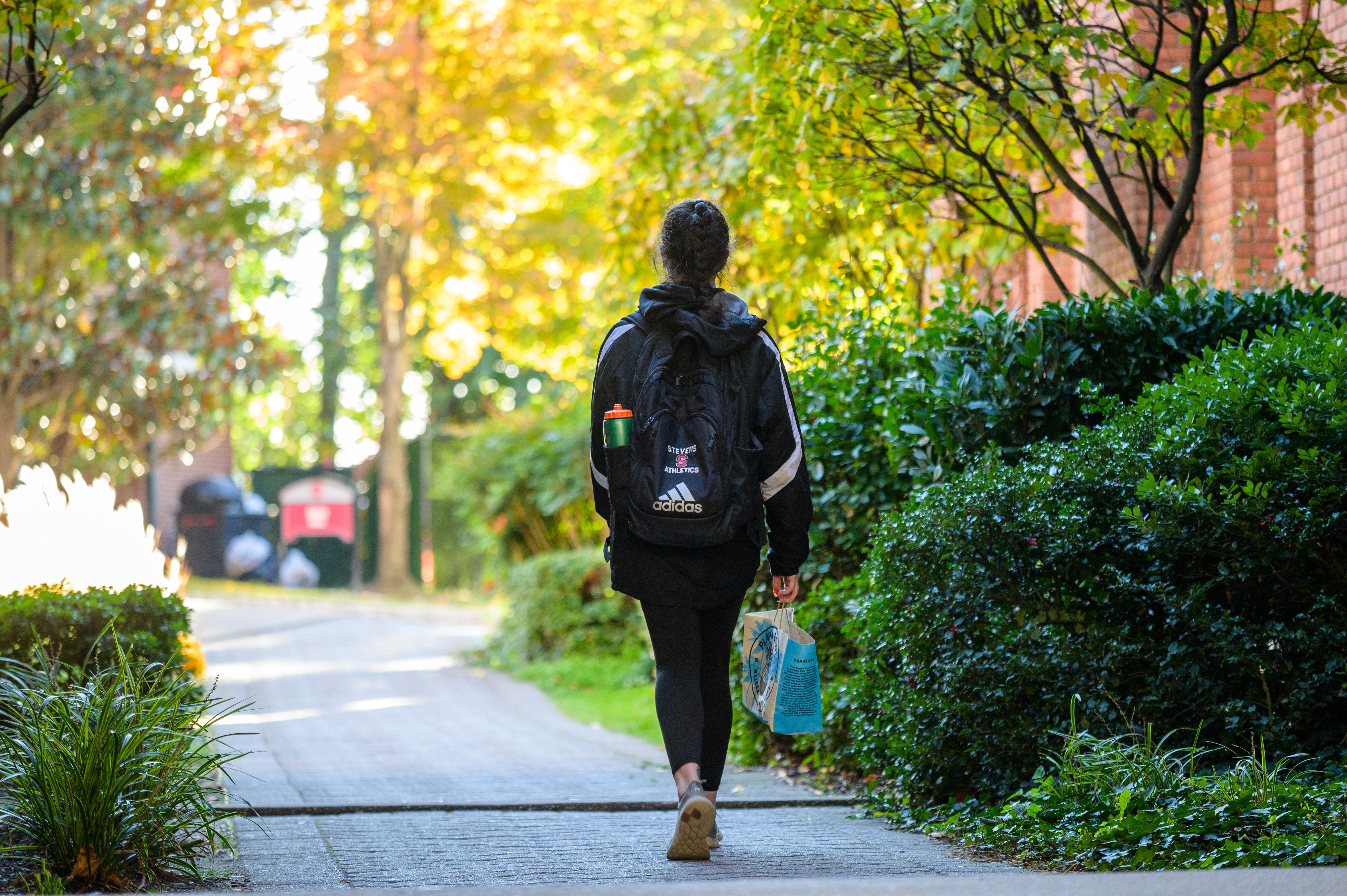 Student walking across campus with backpack