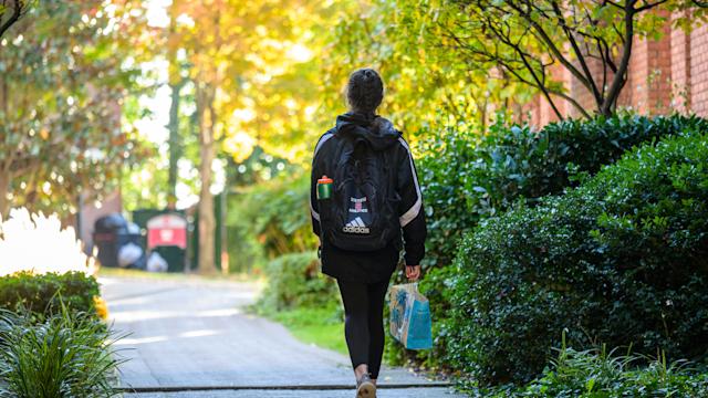 Student walking across campus with backpack