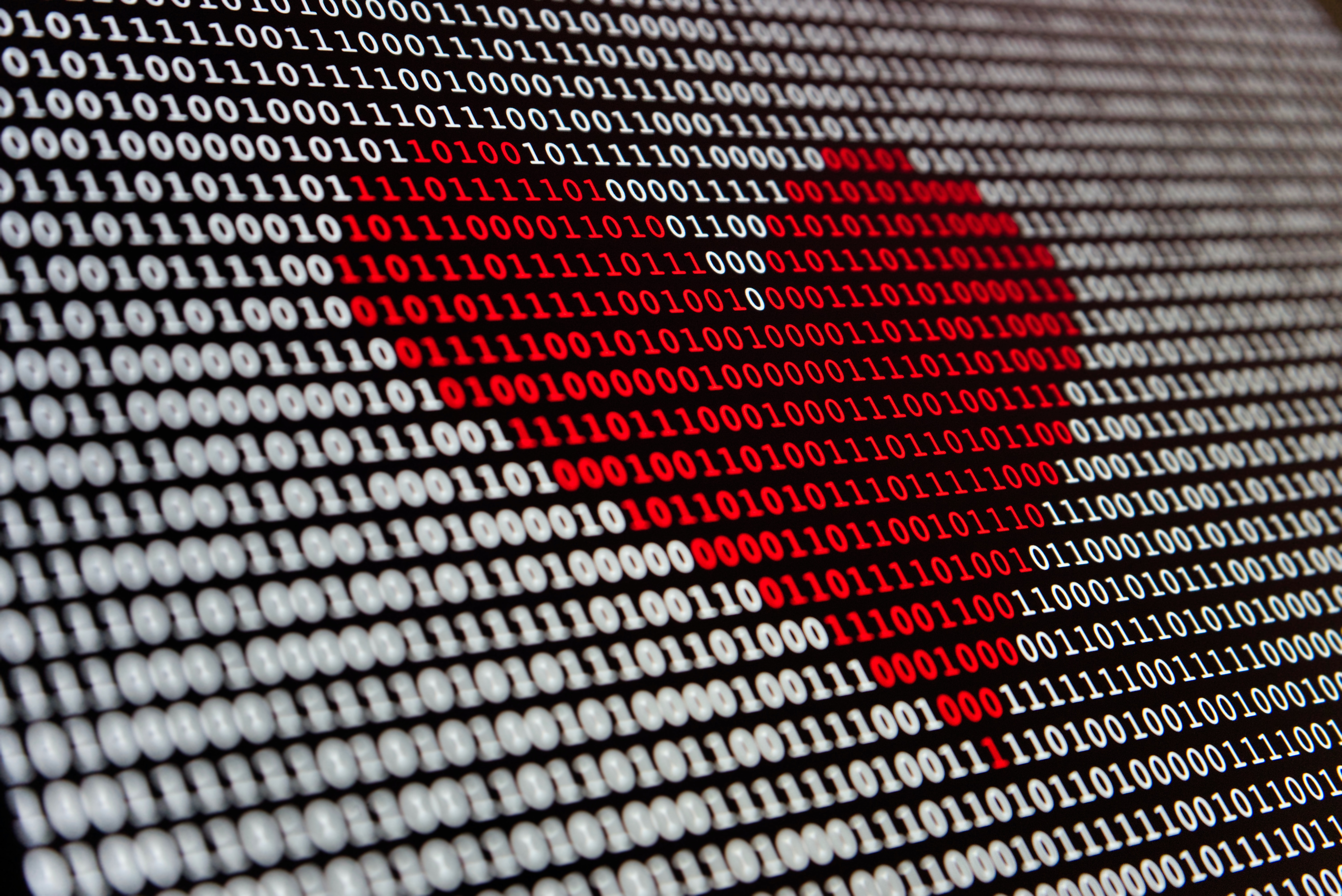 Digital code on computer screen with red-heart shape