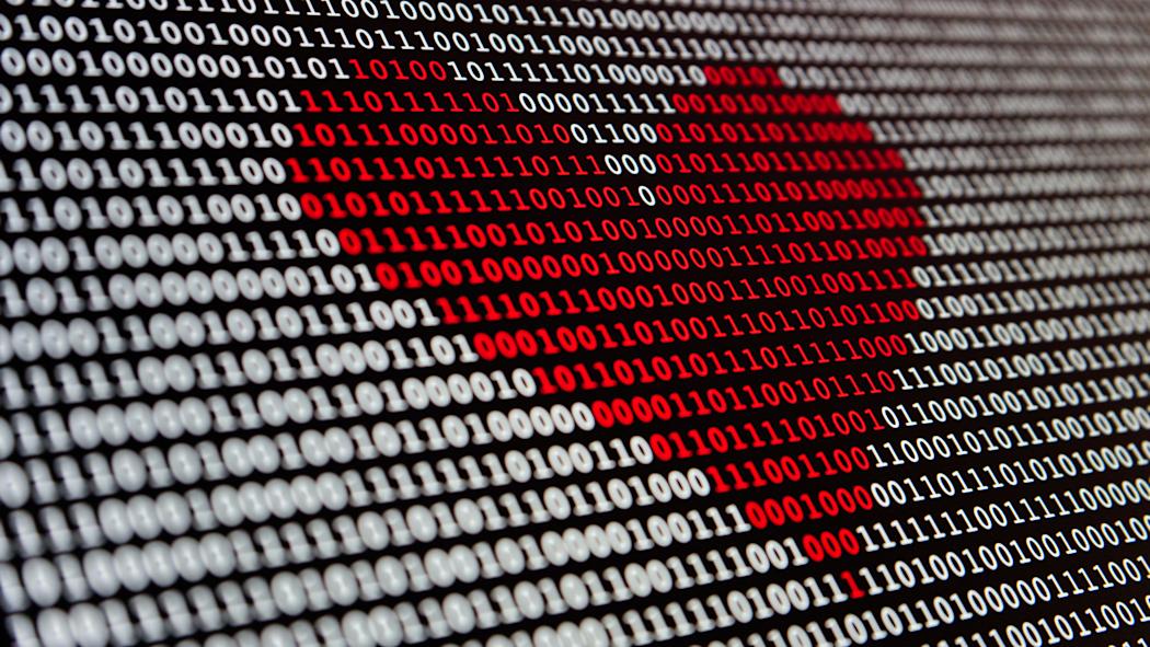 Digital code on computer screen with red-heart shape
