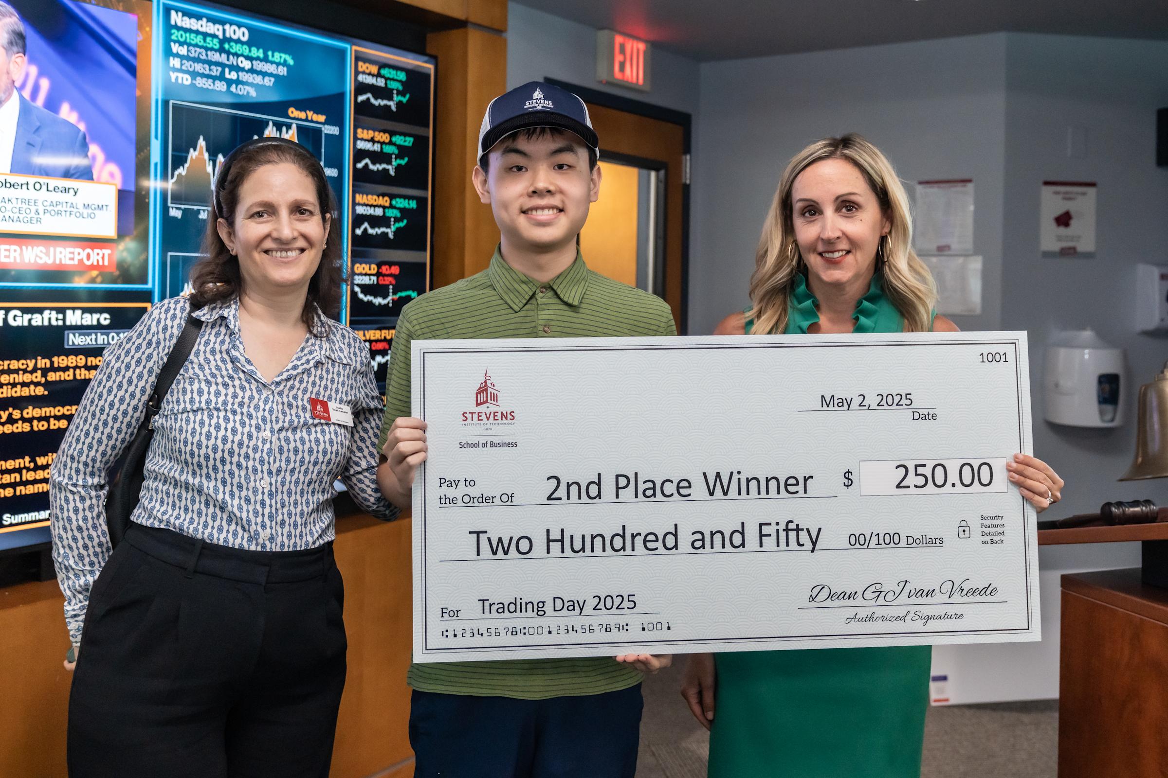 Second-place winner Alex Lin poses with Joelle Saad-Lessler and Lindsay Hartelius holding a giant check for $250.