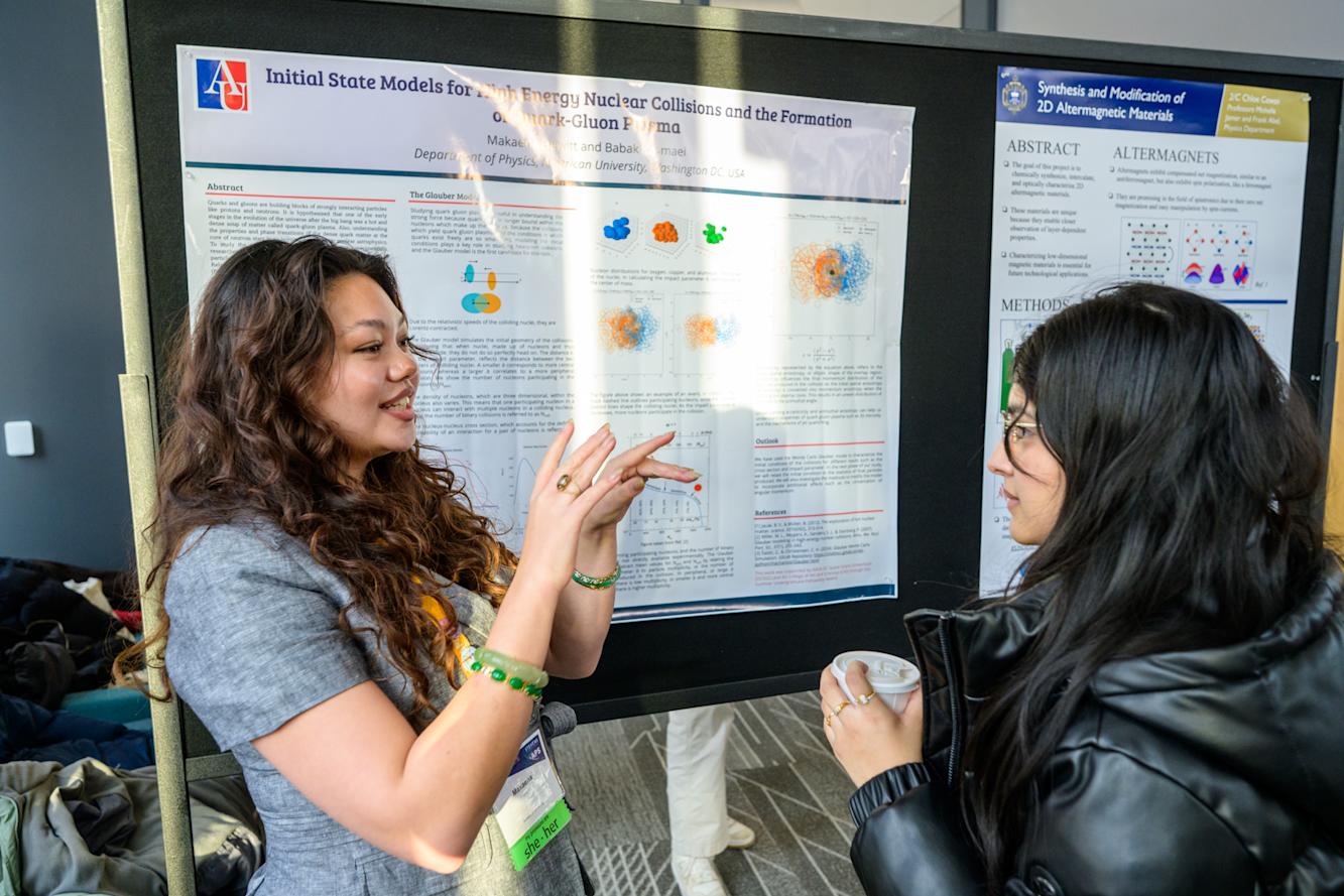 Two students discuss a poster presentation.