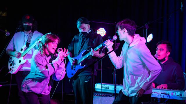 Three musicians and two singers perform as an ensemble