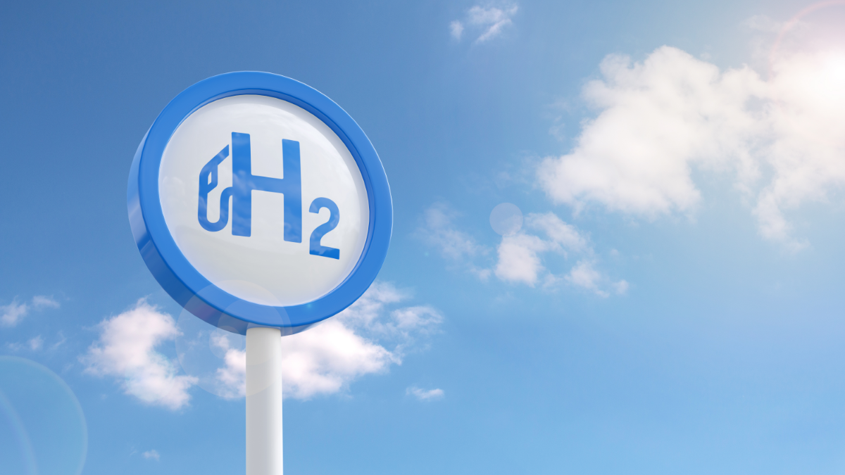 Picture of blue sky with clouds, and a round sign saying "H2" with a fuel pump logo