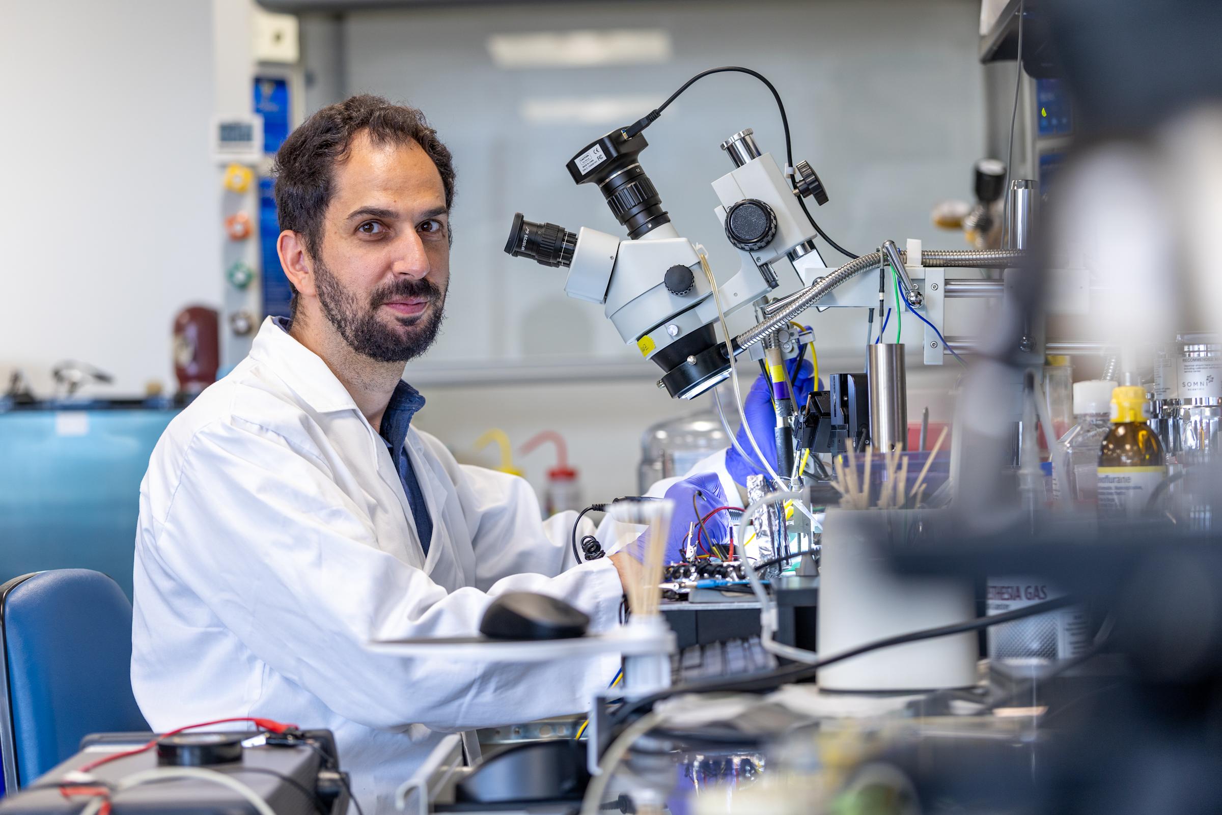 Ilke Uguz looking up from a lab scope. 
