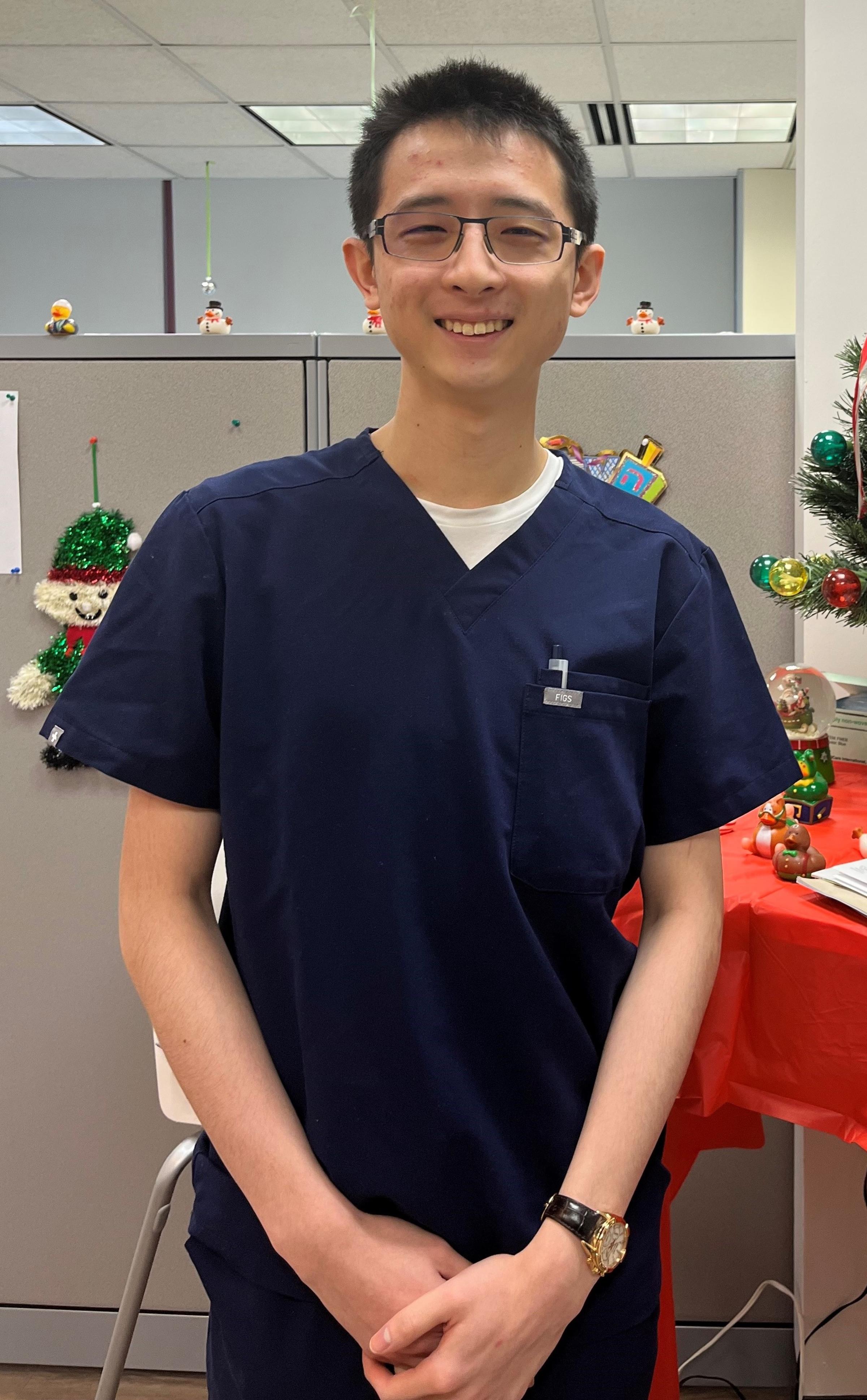 Thompson Hui ‘22 M.S. '23 wearing scrubs from the internship