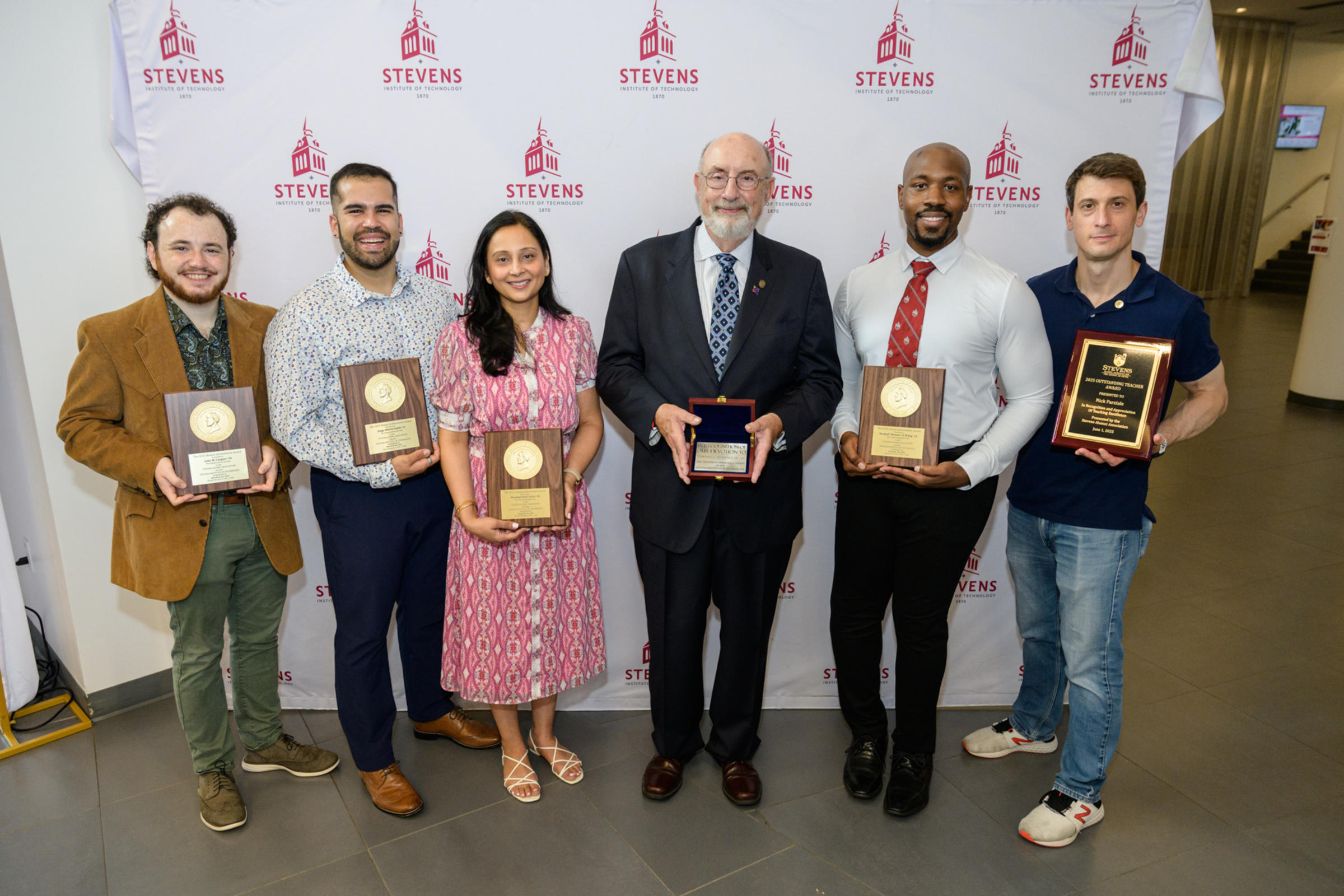 The award winners from Alumni Weekend 2025 pose and hold their awards at the Flock Party and Alumni Awards Presentation