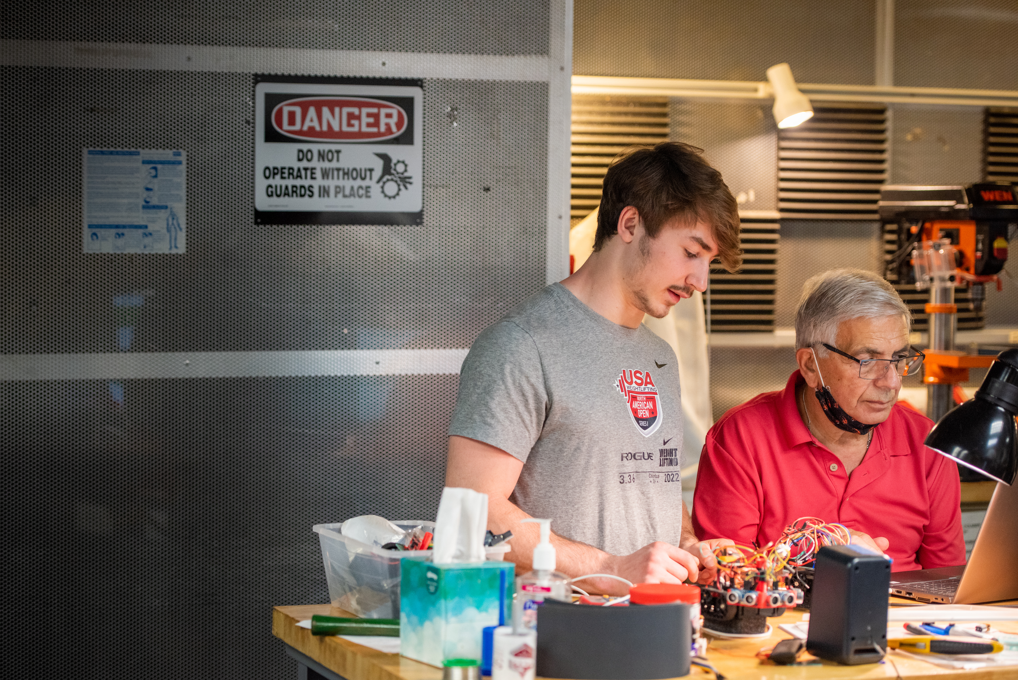 student talking to professor about robotics project