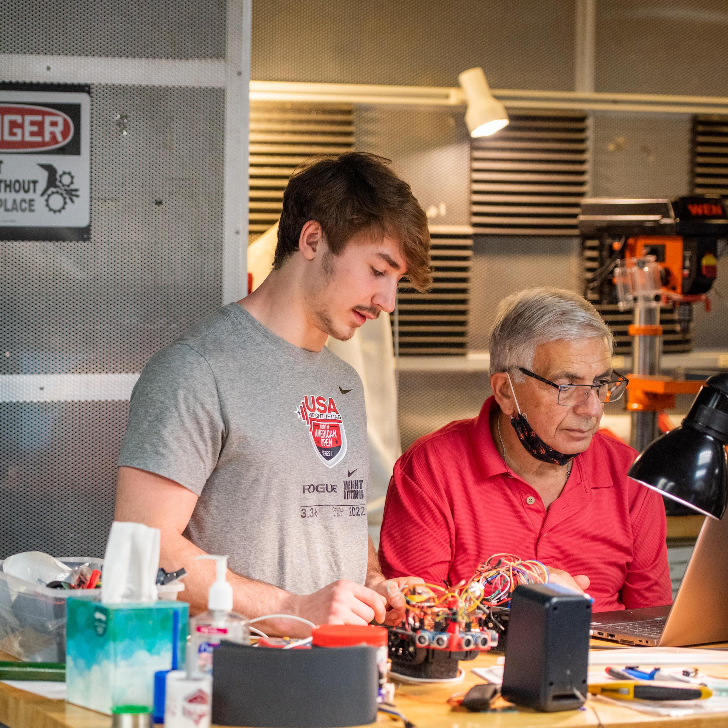 student talking to professor about robotics project