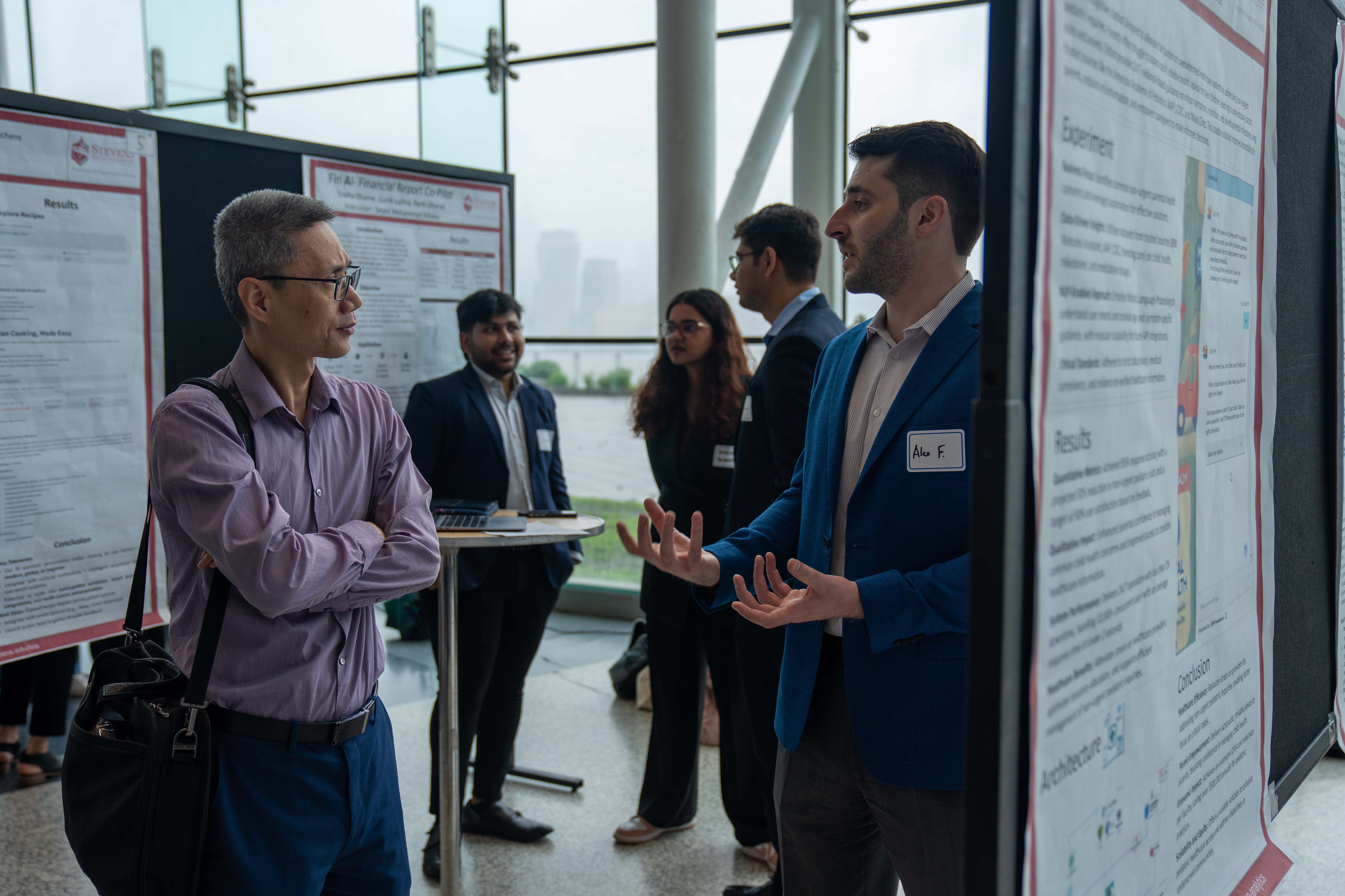 A student shares his research with an industry guest