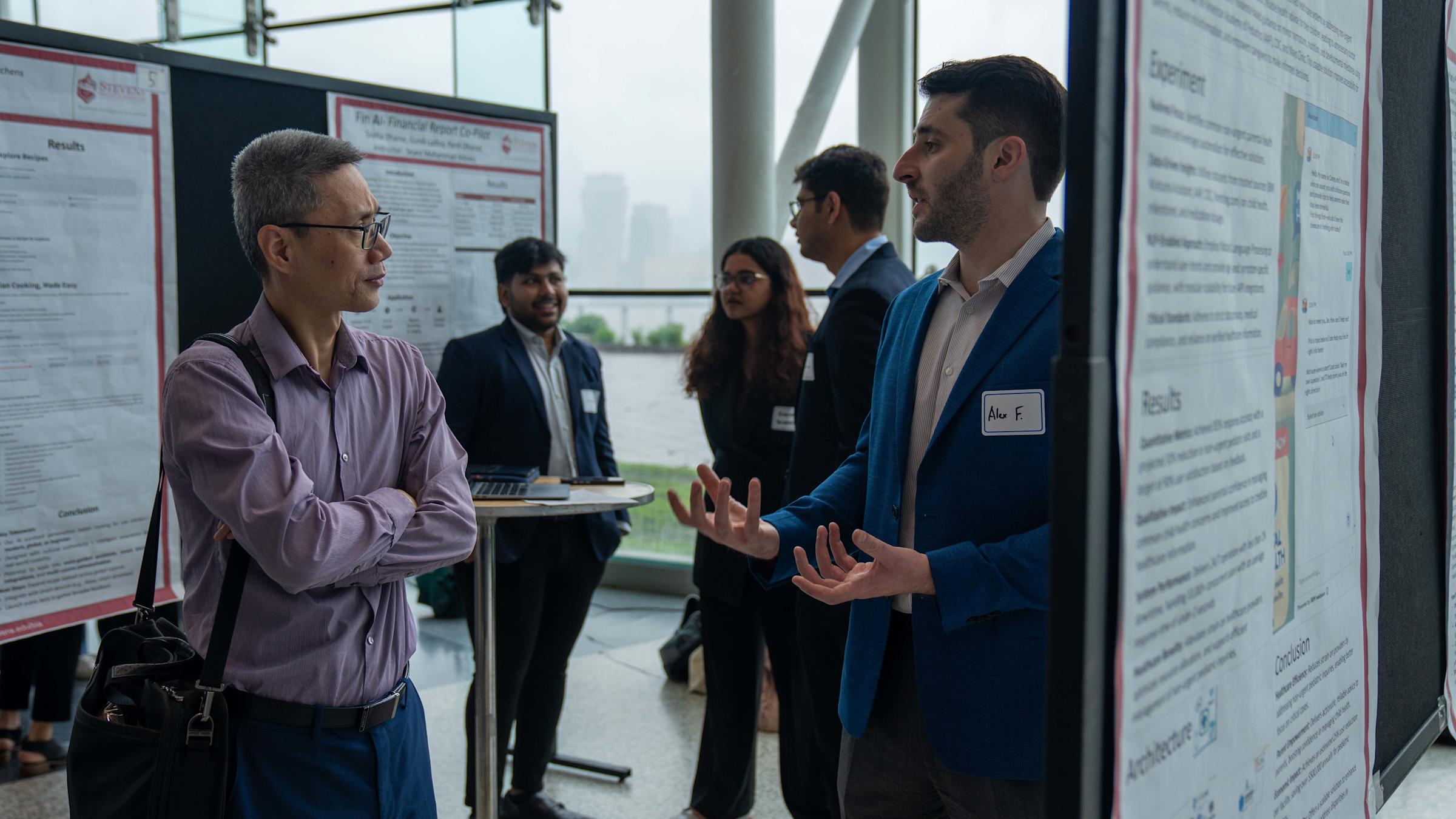 A student shares his research with an industry guest