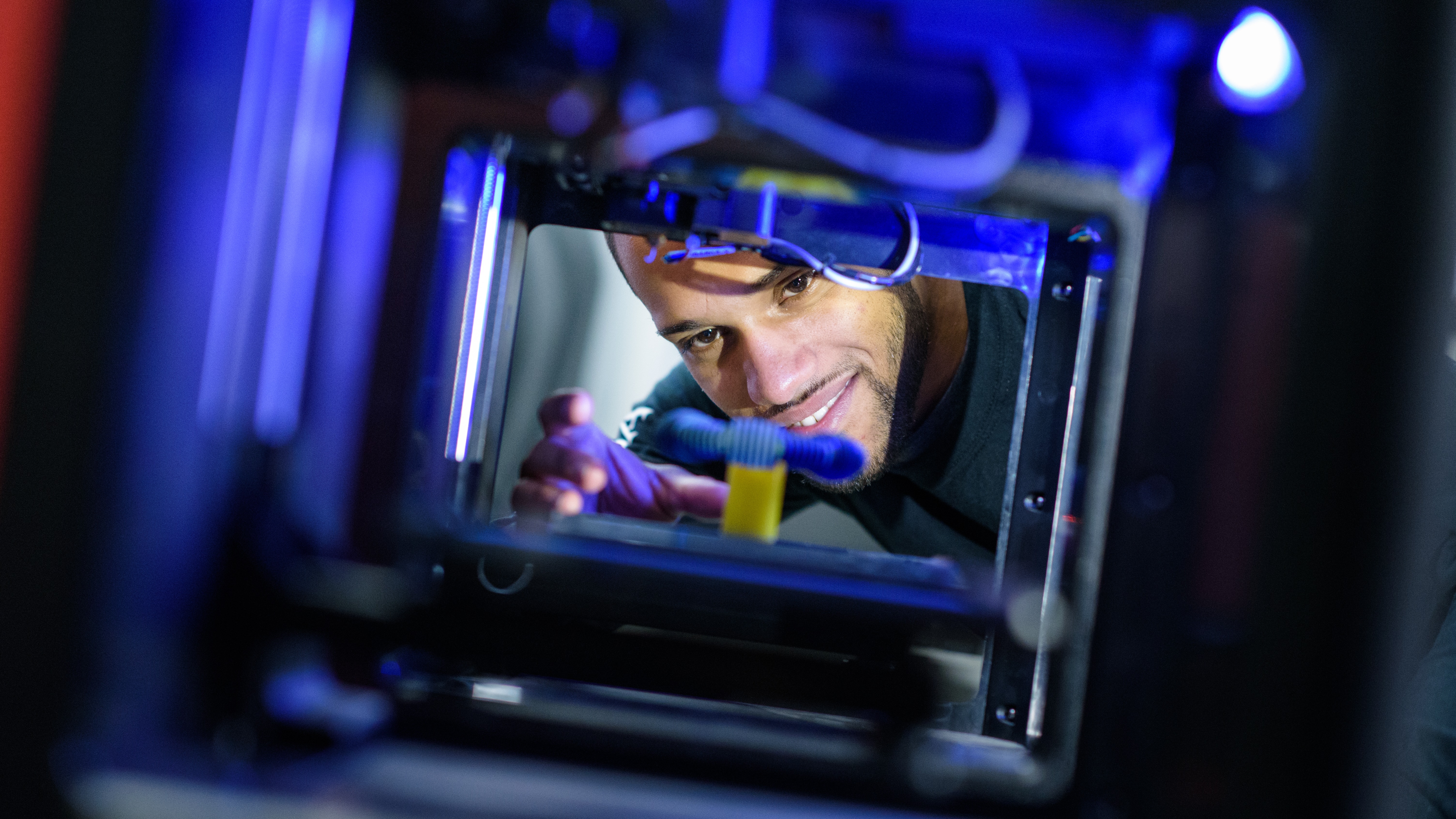 Student looking through viewer of engineering manufacturing equipment. 