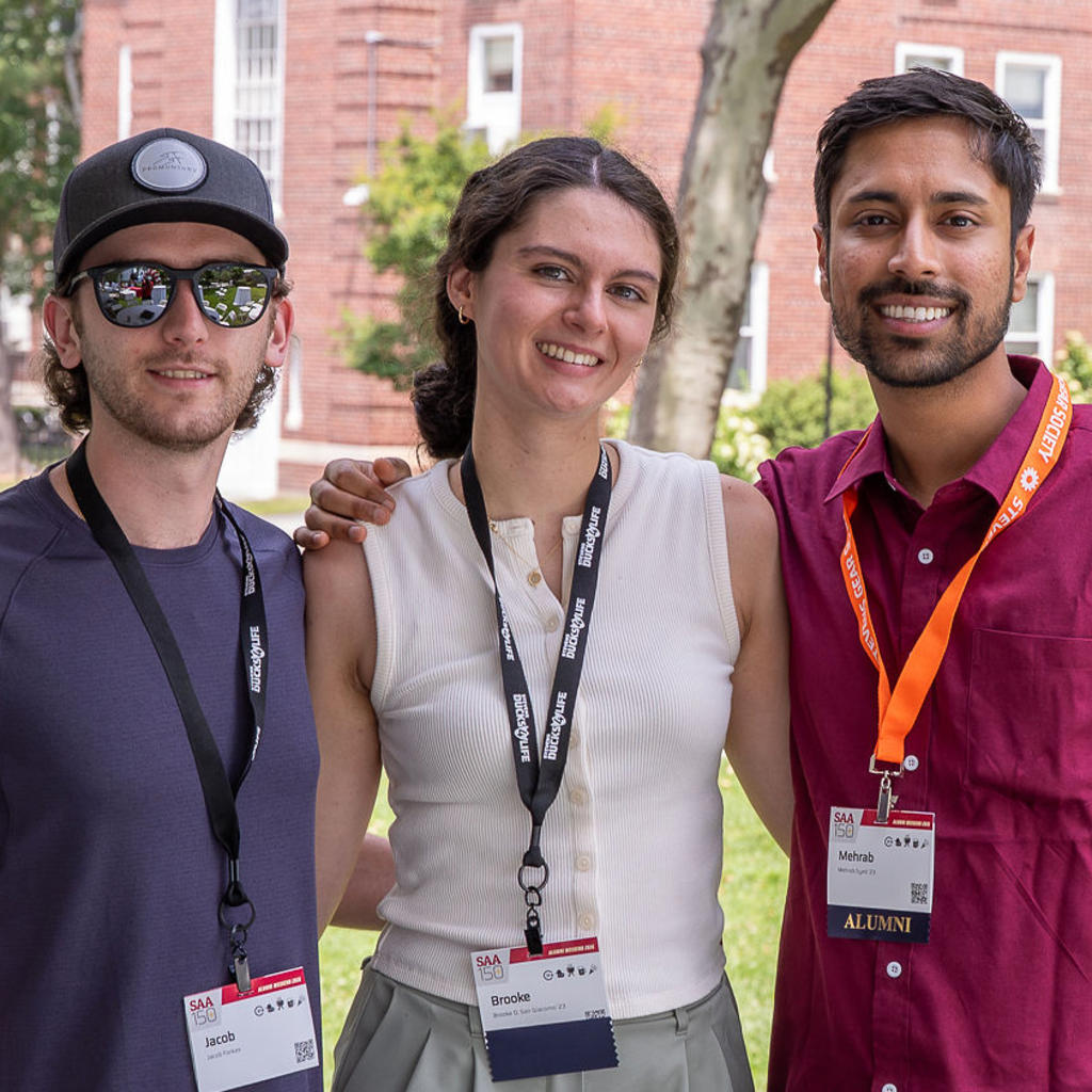 Three young alumni outside on Stevens campus at Alumni Weekend 2026