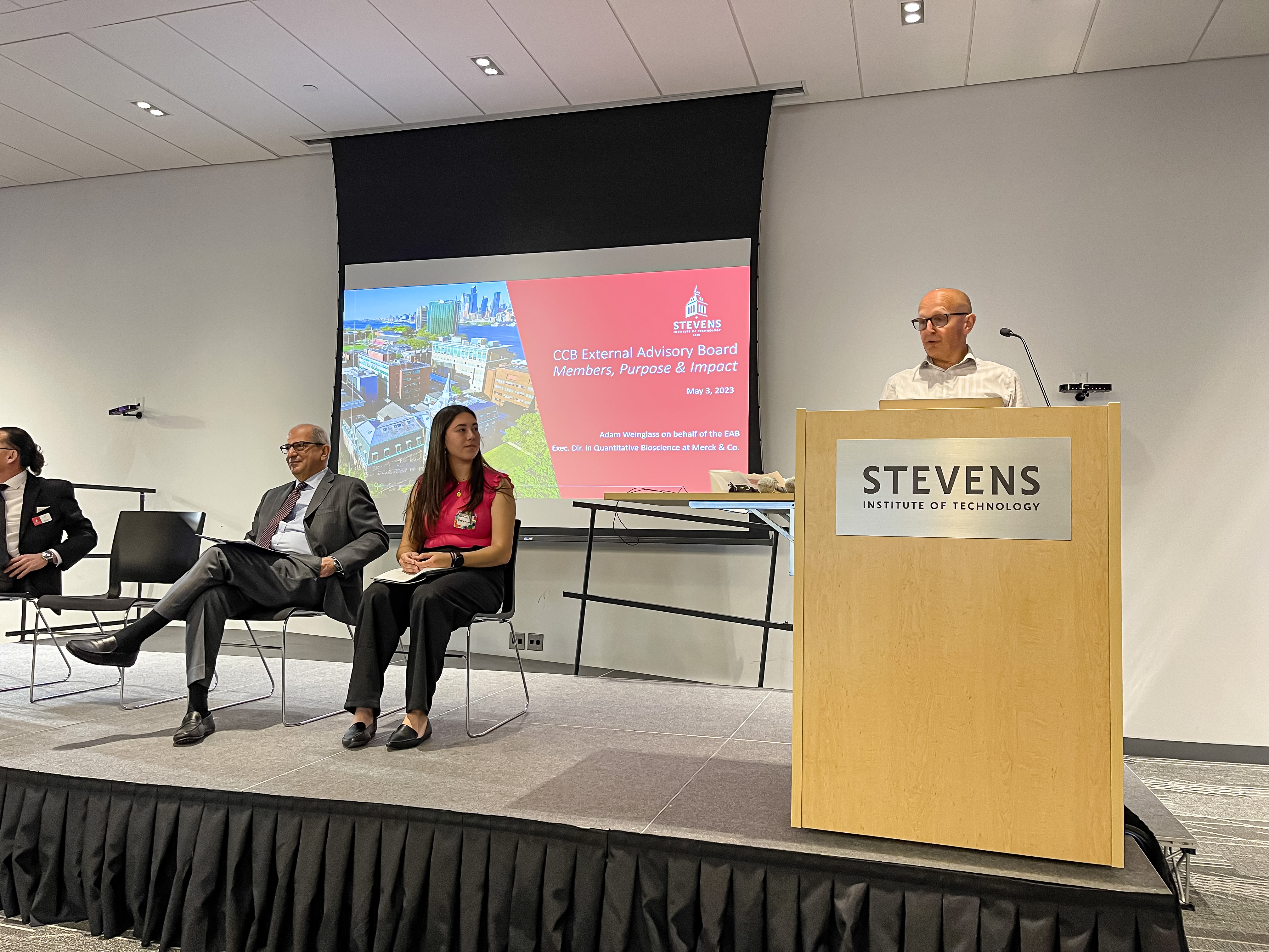 Executive Advisory Board member Adam Weinglass speaks at a podium.