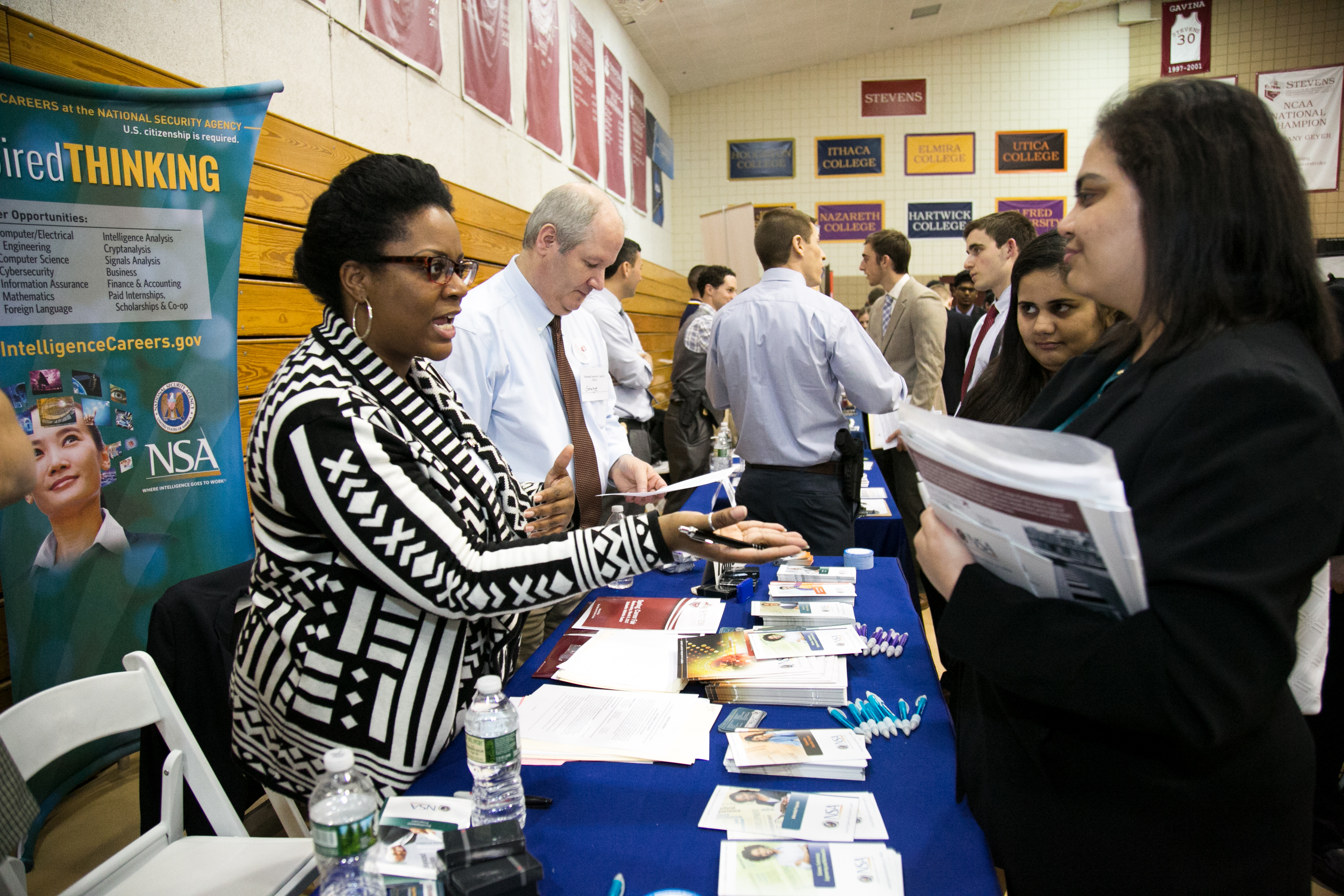 Women standing at a booth with brochures and pens