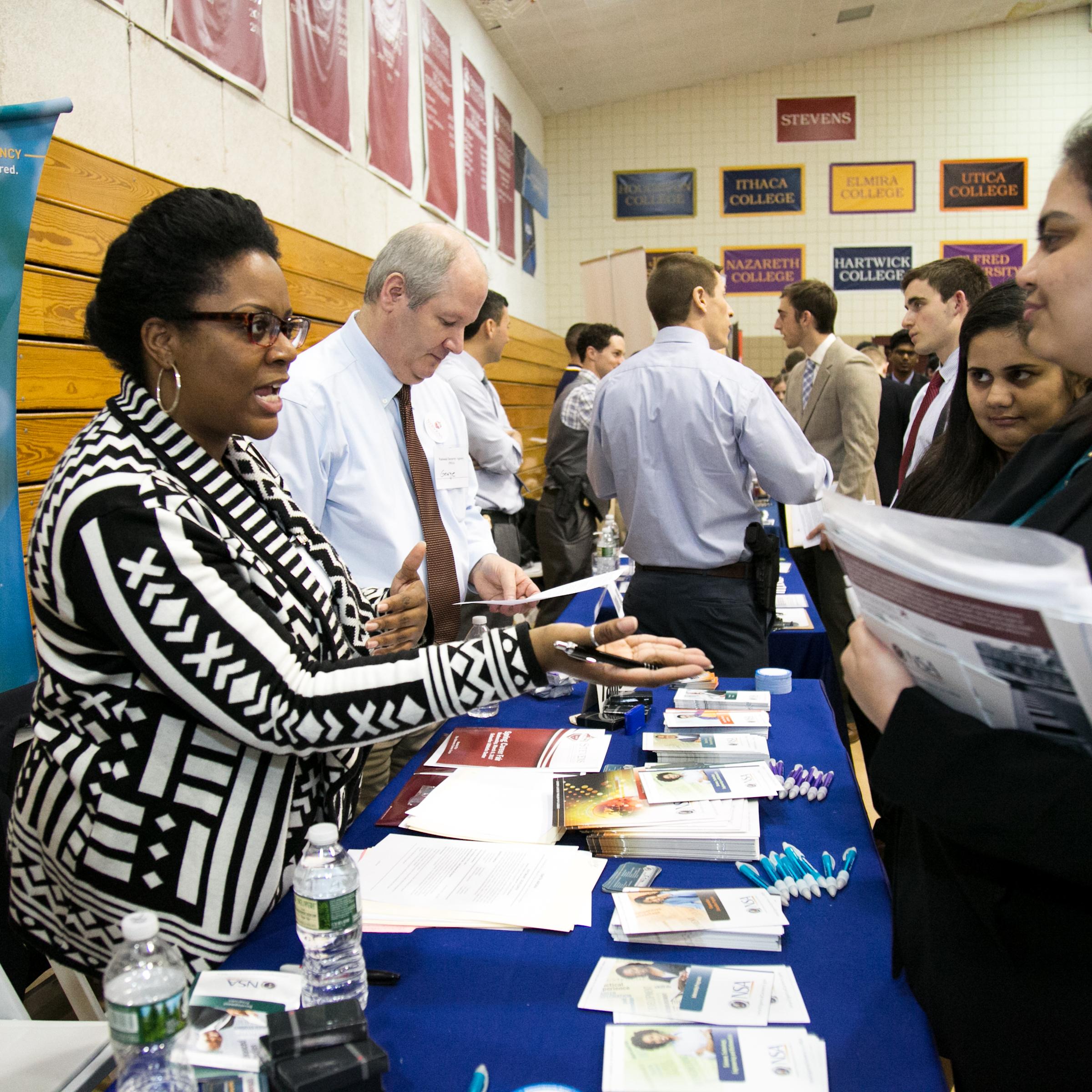 Women standing at a booth with brochures and pens