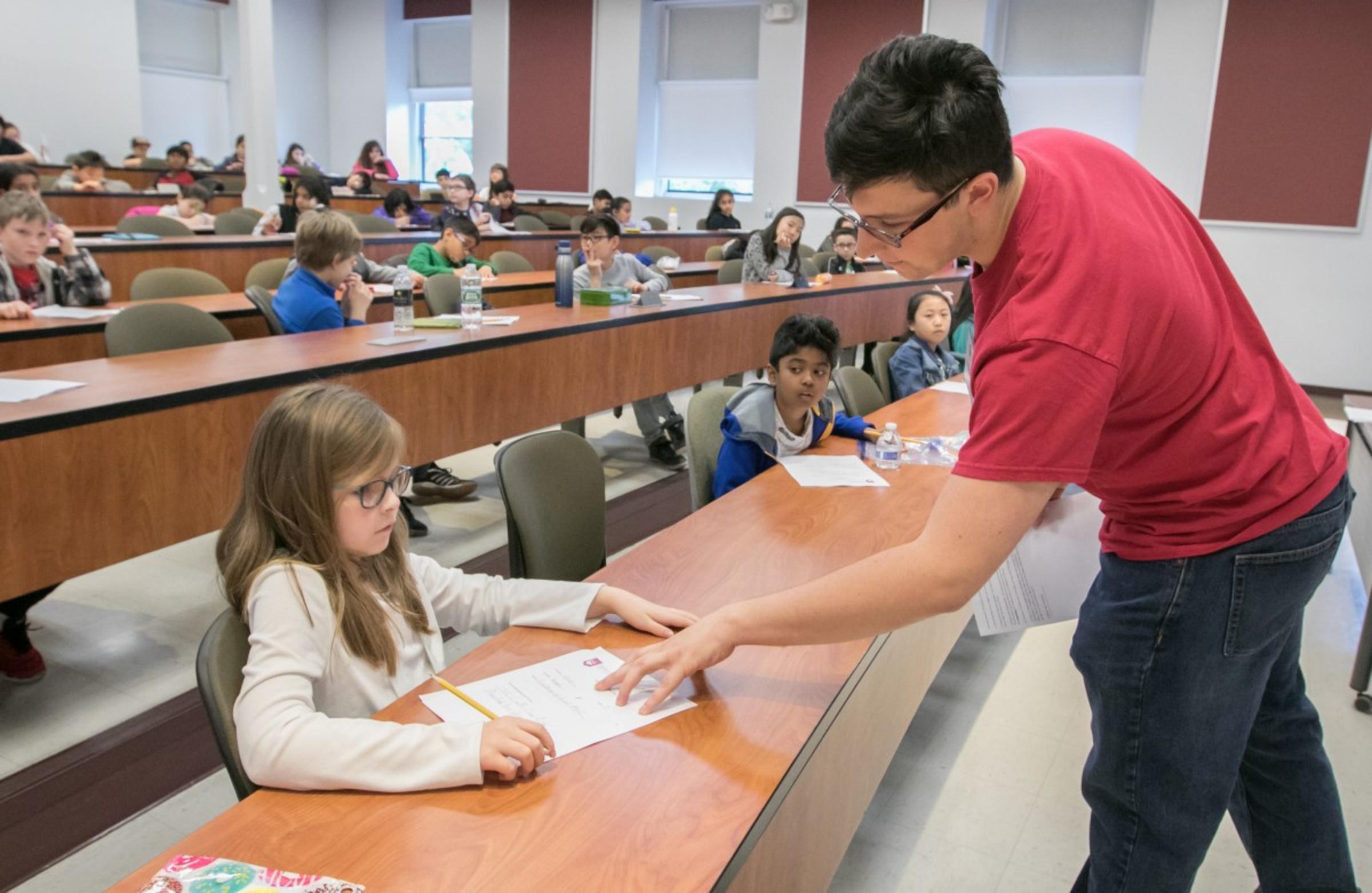 A Stevens student helps a small child in a classroom