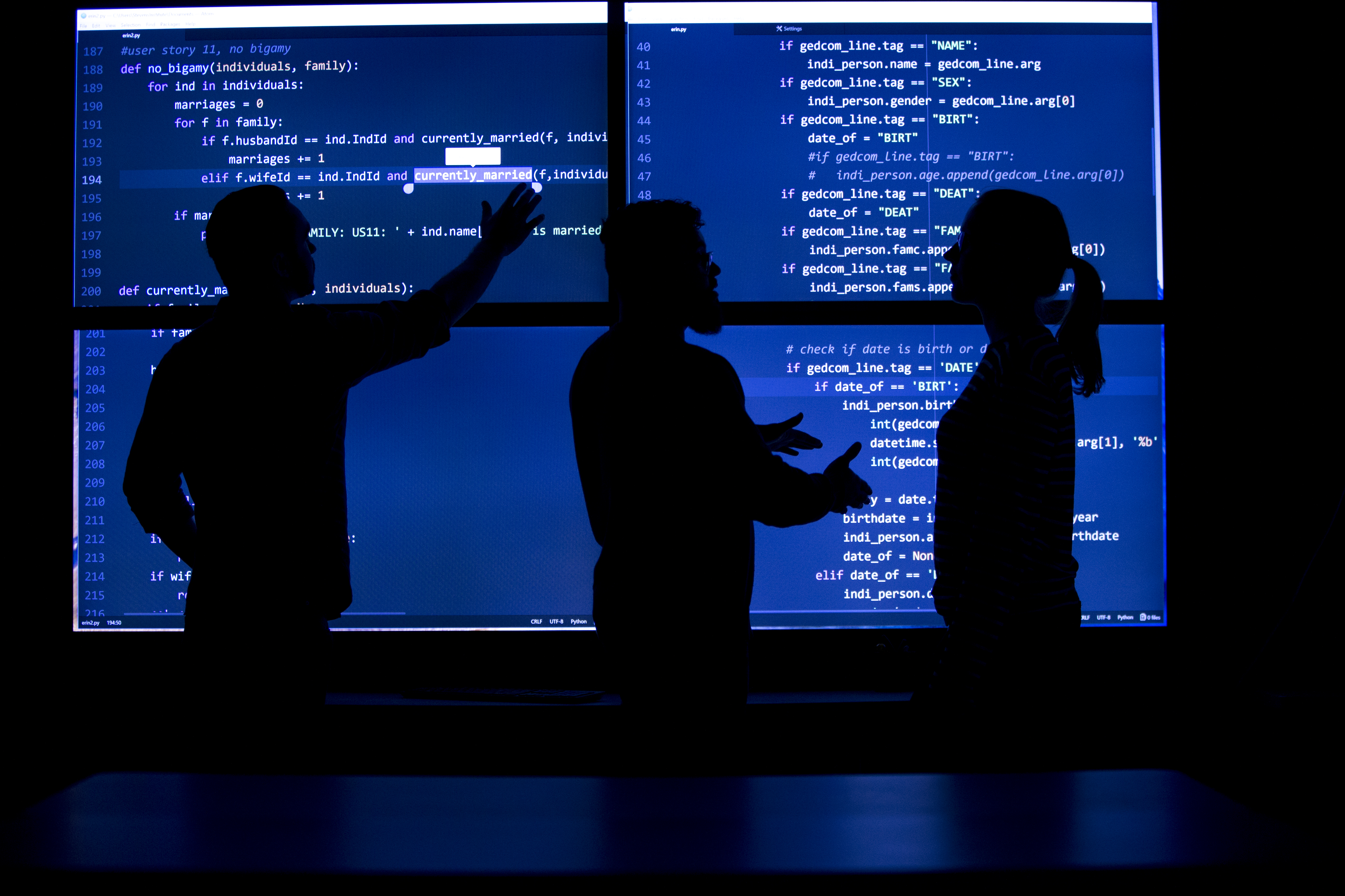 Three students silhouettes on 4 large, blue, computer screens
