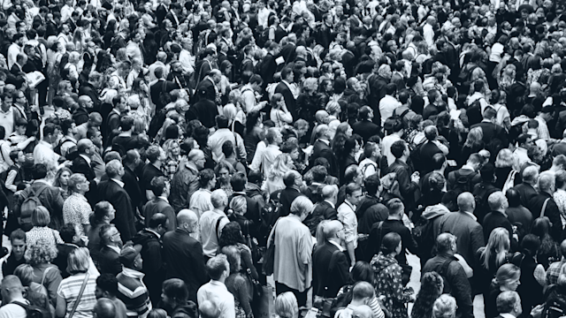 Crowd of people. black and white with light blue overlay.