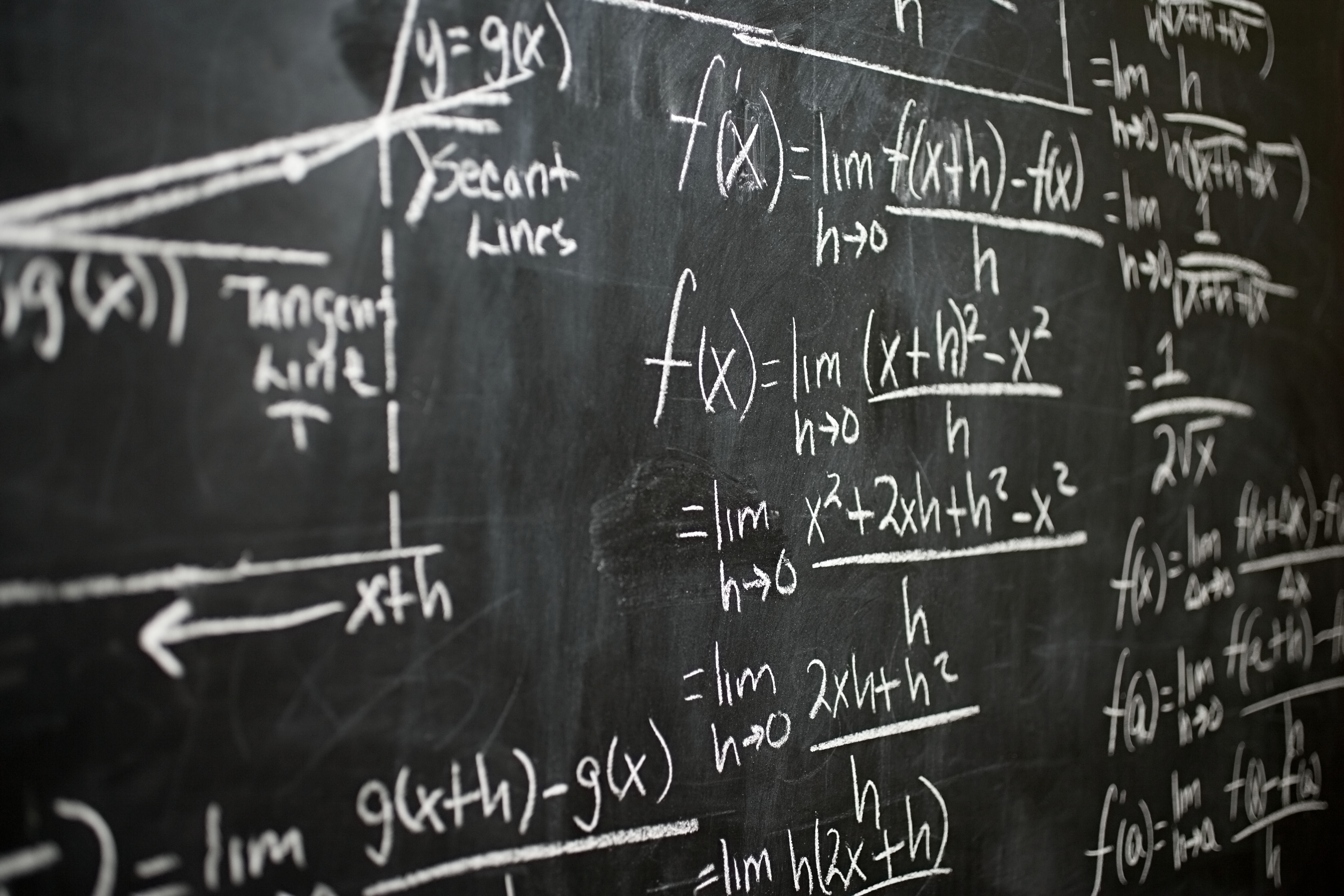 Calculus equations written on a blackboard in chalk. 