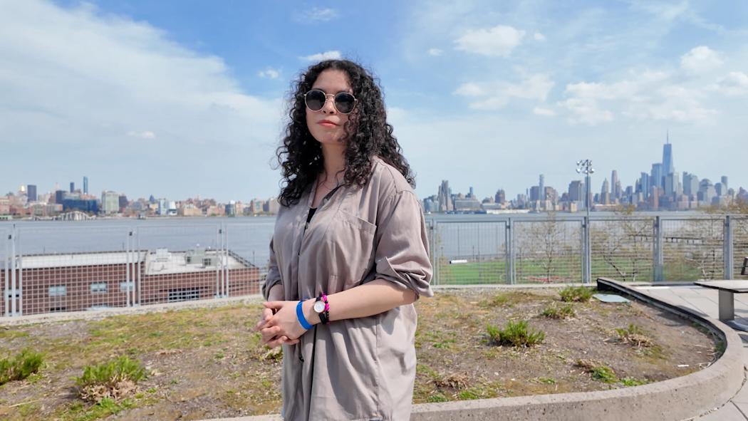 Emily Lossman posing in front of the NYC skyline.
