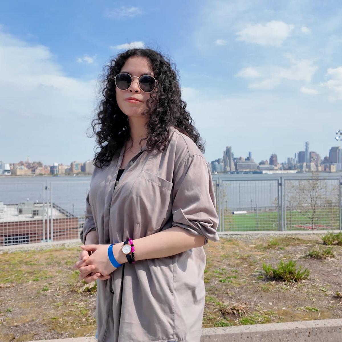 Emily Lossman posing in front of the NYC skyline.