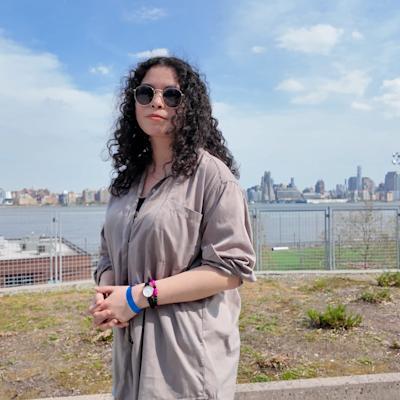 Emily Lossman posing in front of the NYC skyline.