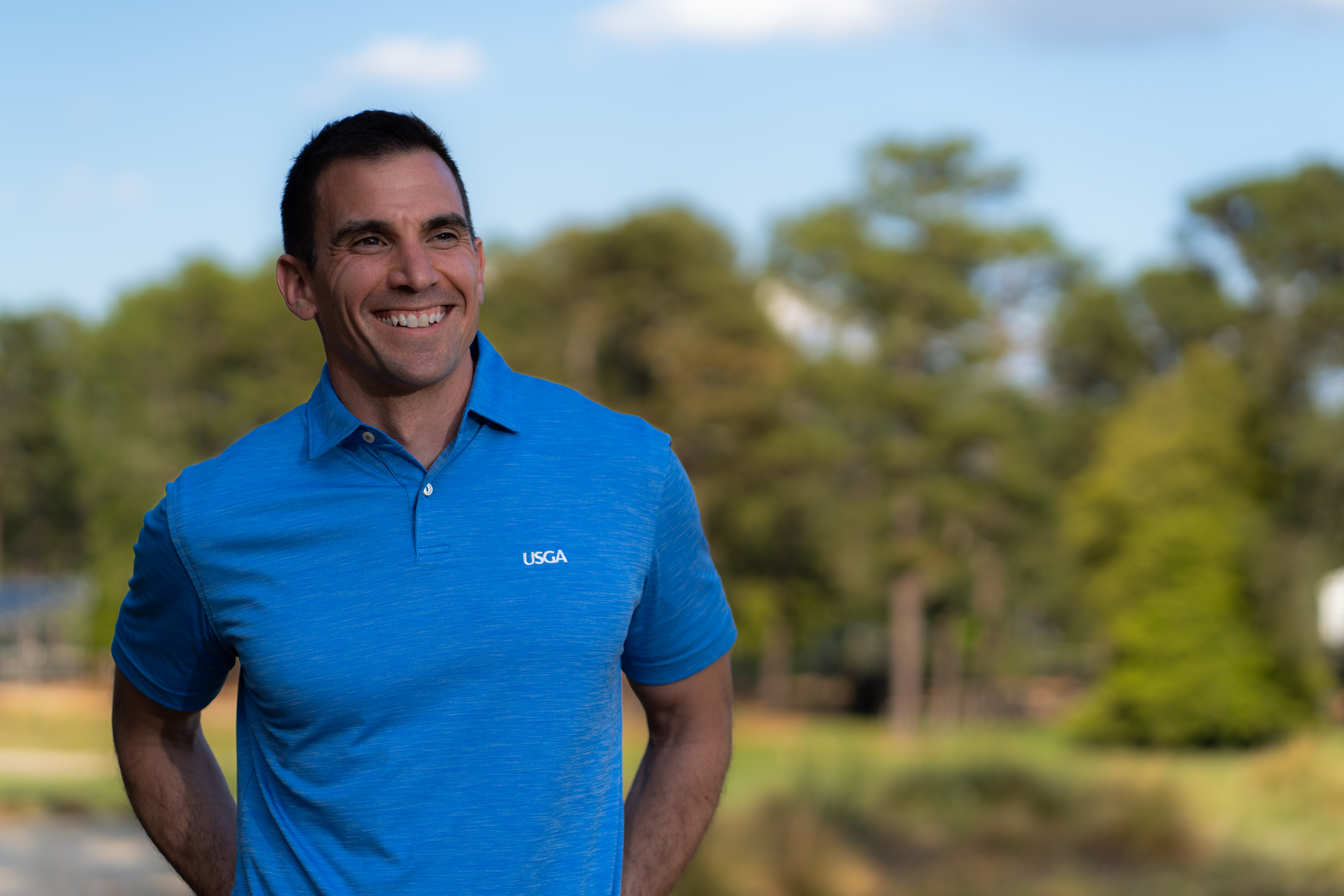 Anthony Santora M.S. ’05 headshot outside wearing a blue USGA shirt